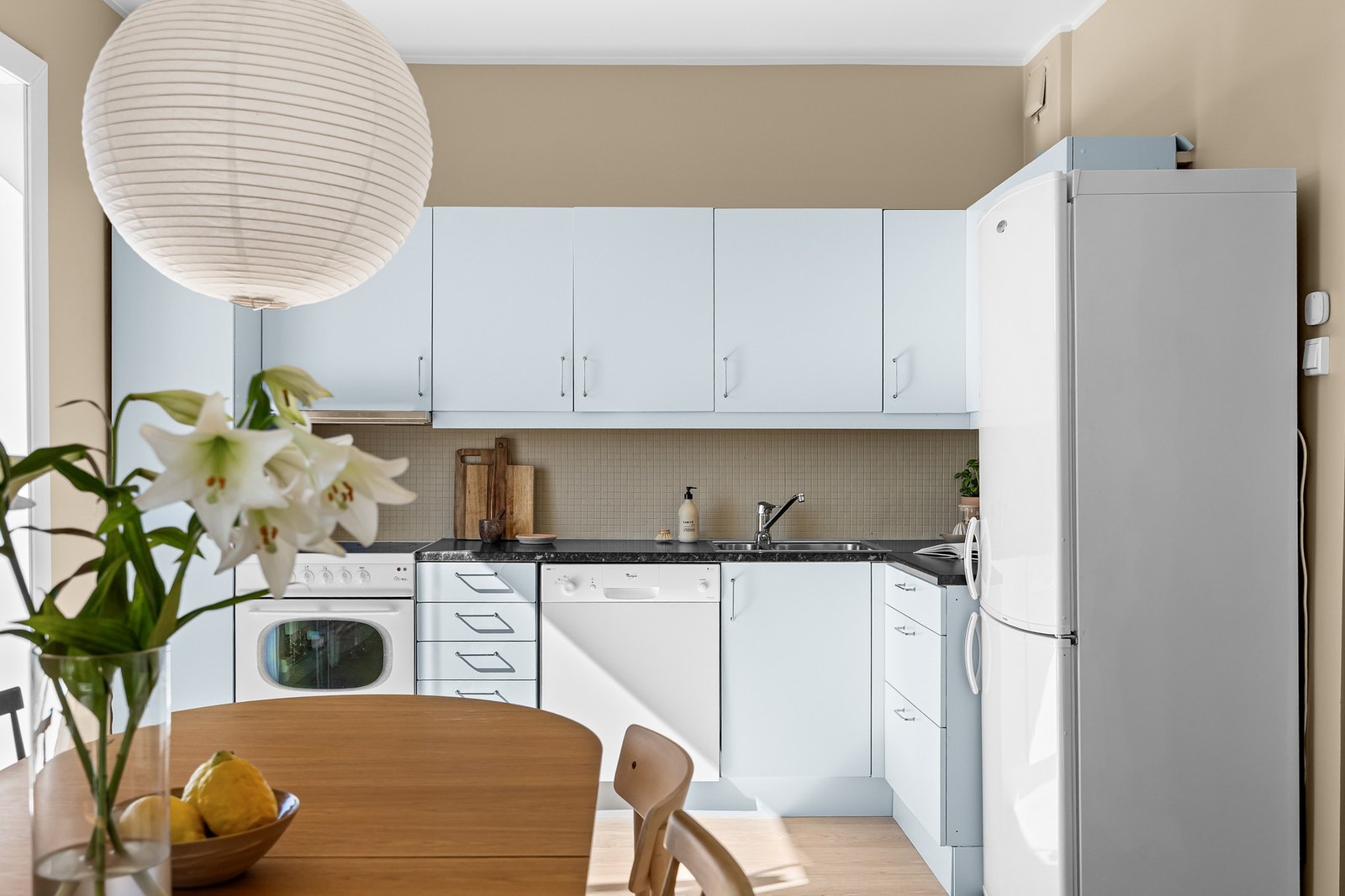 Kjøkkeninnredningen fra ukjent år, med glatte fronter og benkeplate av laminat. Galleribilde