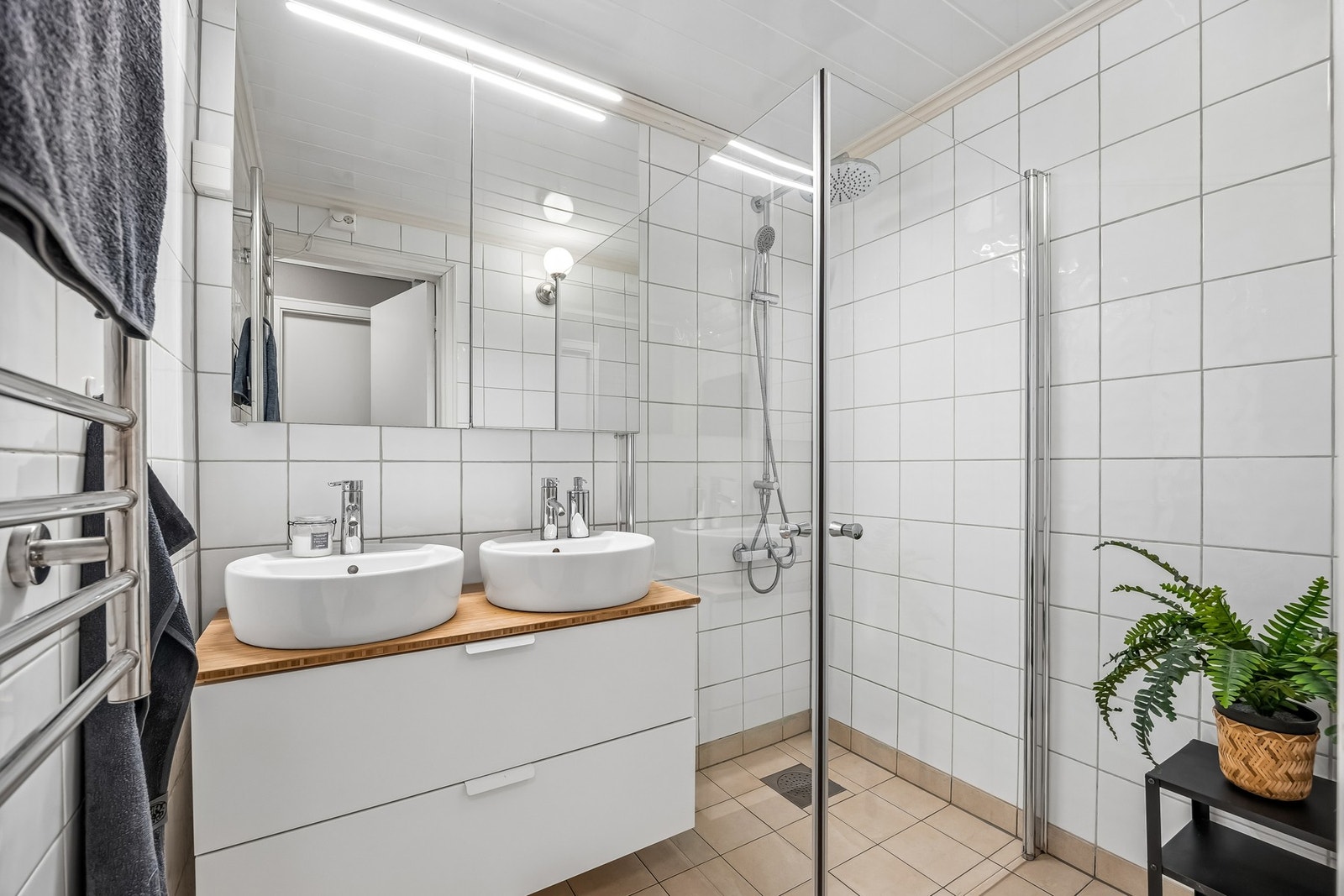 Badet har en moderne og stilren utforming med flislagte gulv og vegger samt elektrisk gulvvarme som gir god komfort. Galleribilde