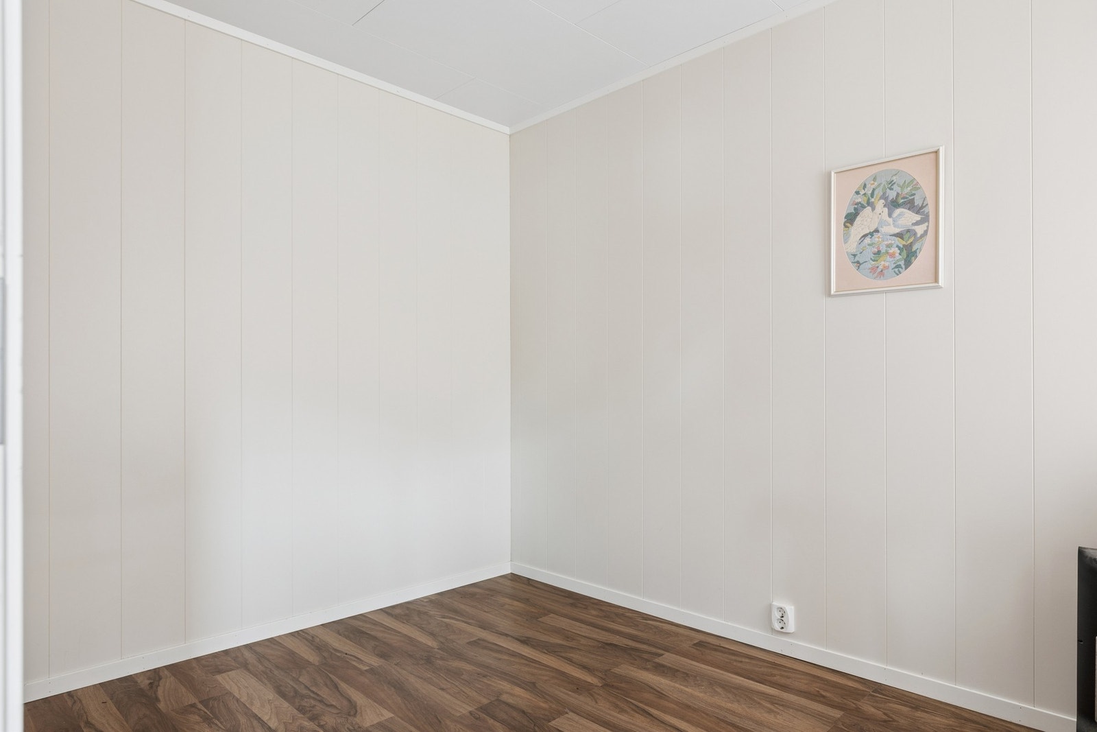 Rom med laminatgulv og malte panelplater på veggene. Galleribilde