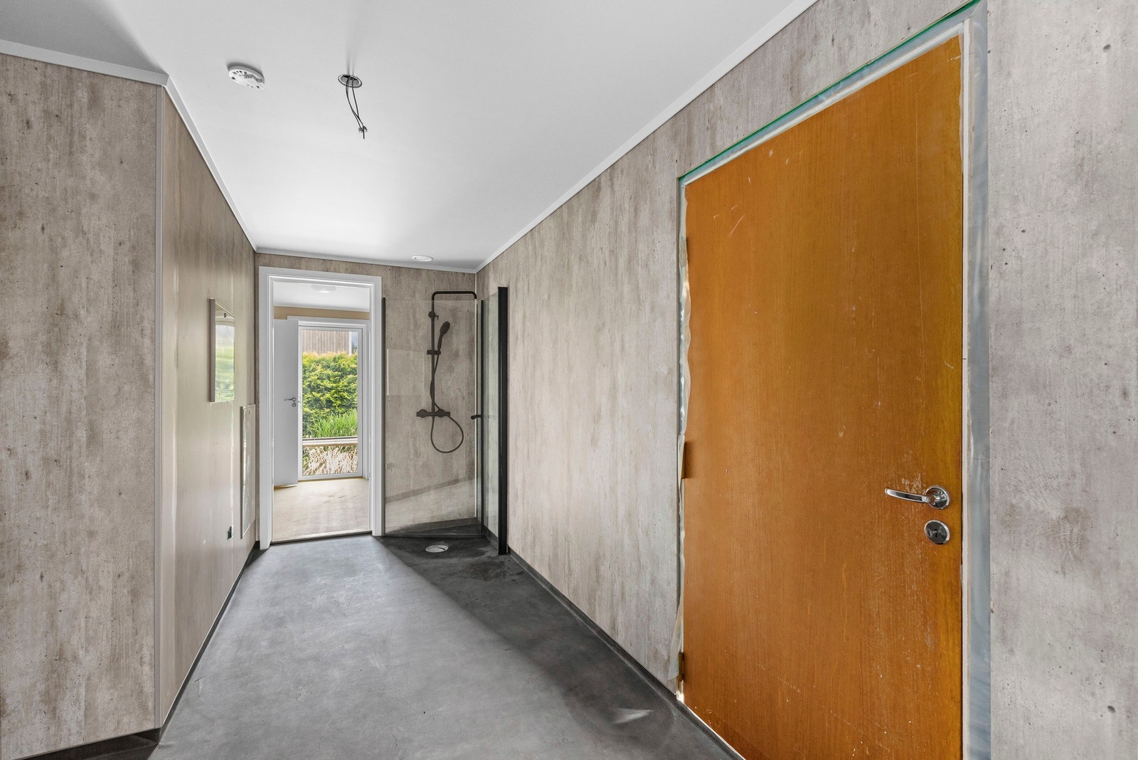 Vaskerom med dør inn til garasjen (til høyre) og dør inn til kontor. Galleribilde