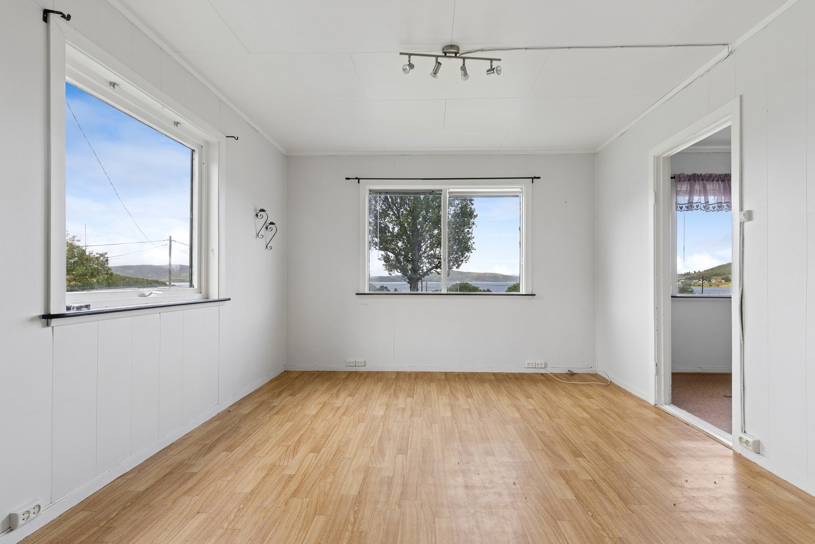 Vegger med trepanel og malte plater, og himlingsplater i taket. Galleribilde