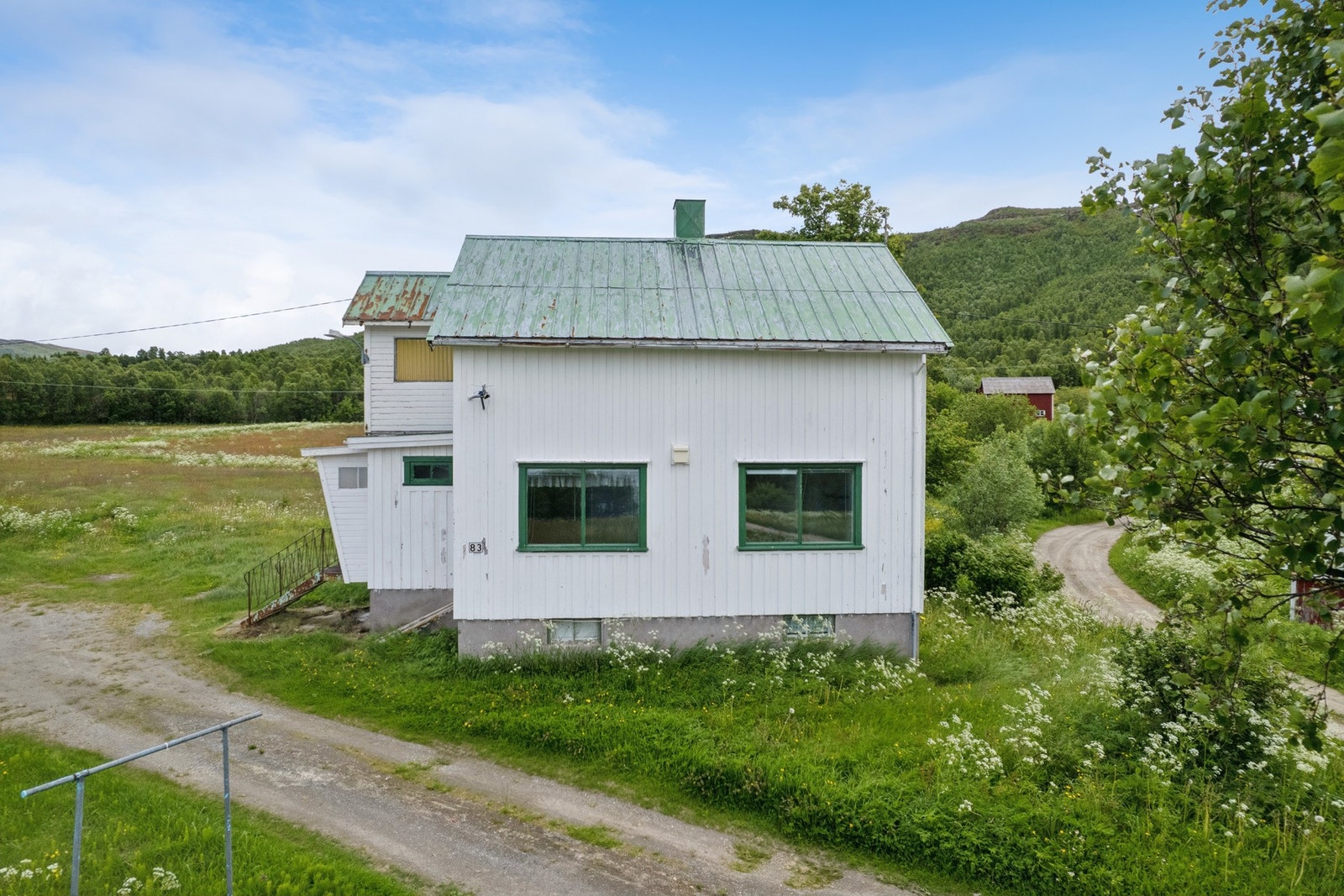Fasaden er kledd med stående bordkledning og metallplater. Galleribilde