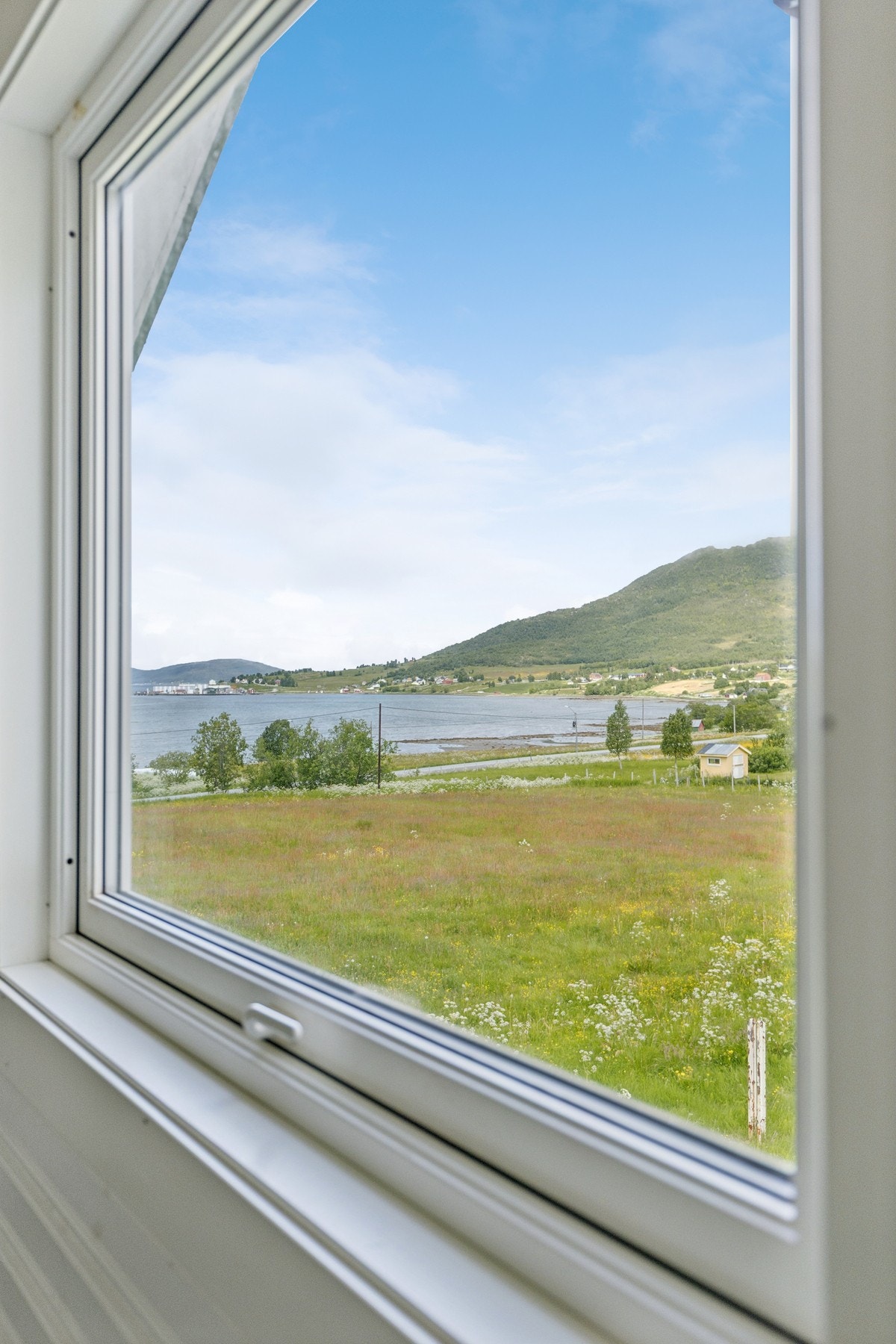 Vinduet på loftet rammer inn utsikten mot det omkringliggende kulturlandskapet. Galleribilde