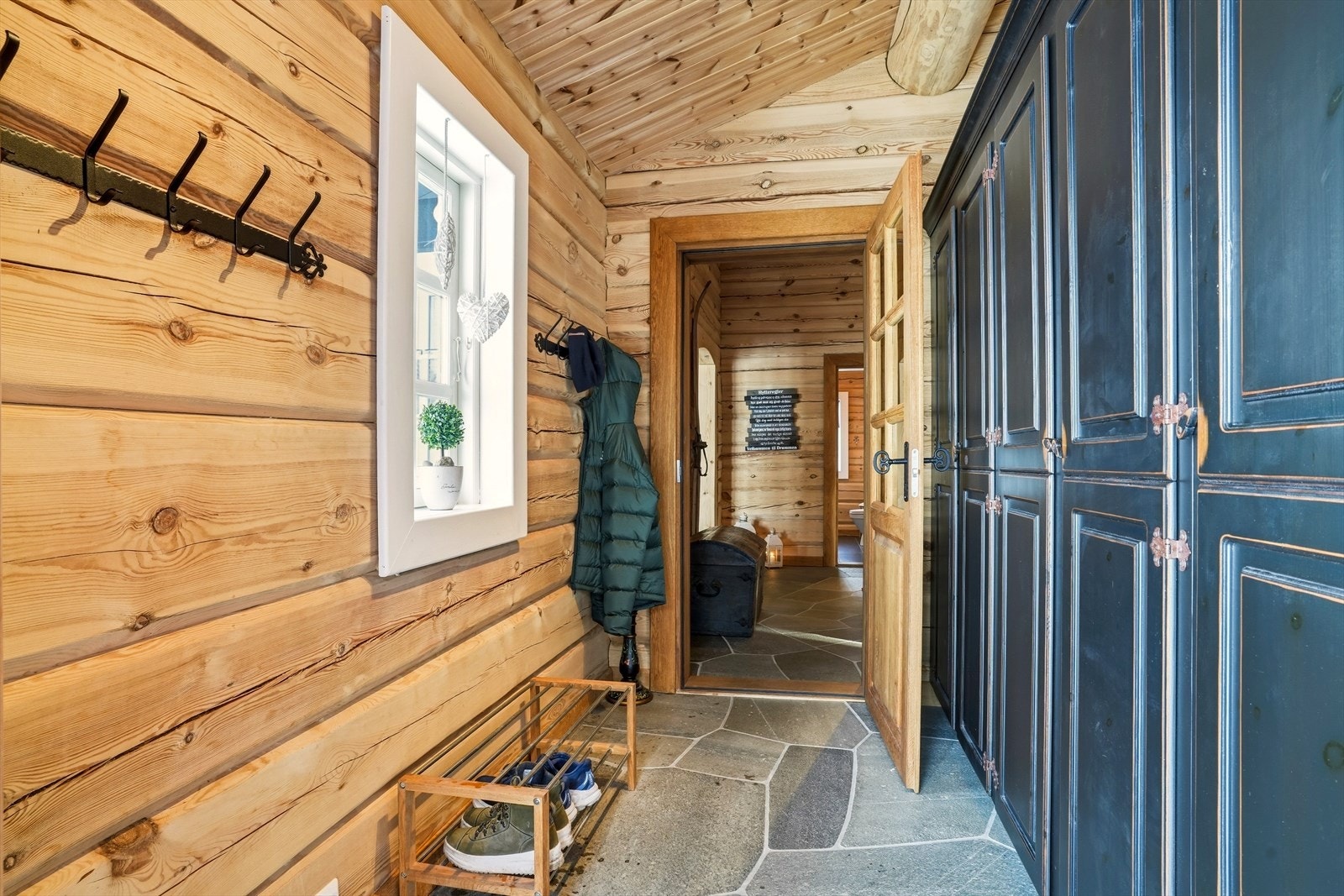 Velkommen inn! Entrè og gang er skiferlagt med varme i gulvene. På høyre side har man en flott plassbygd innredning med masse god skapplass. Galleribilde