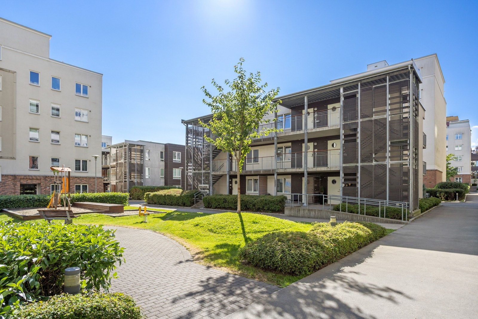 Det er bilfritt og pent beplantet fellesareal mellom bebyggelsen på boligfeltet. Galleribilde