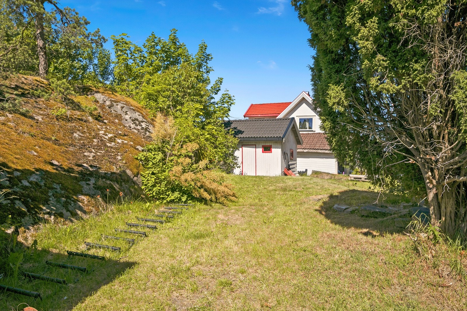 Tomten er stor med grønne uteområder bestående av plen og naturtomt. Galleribilde