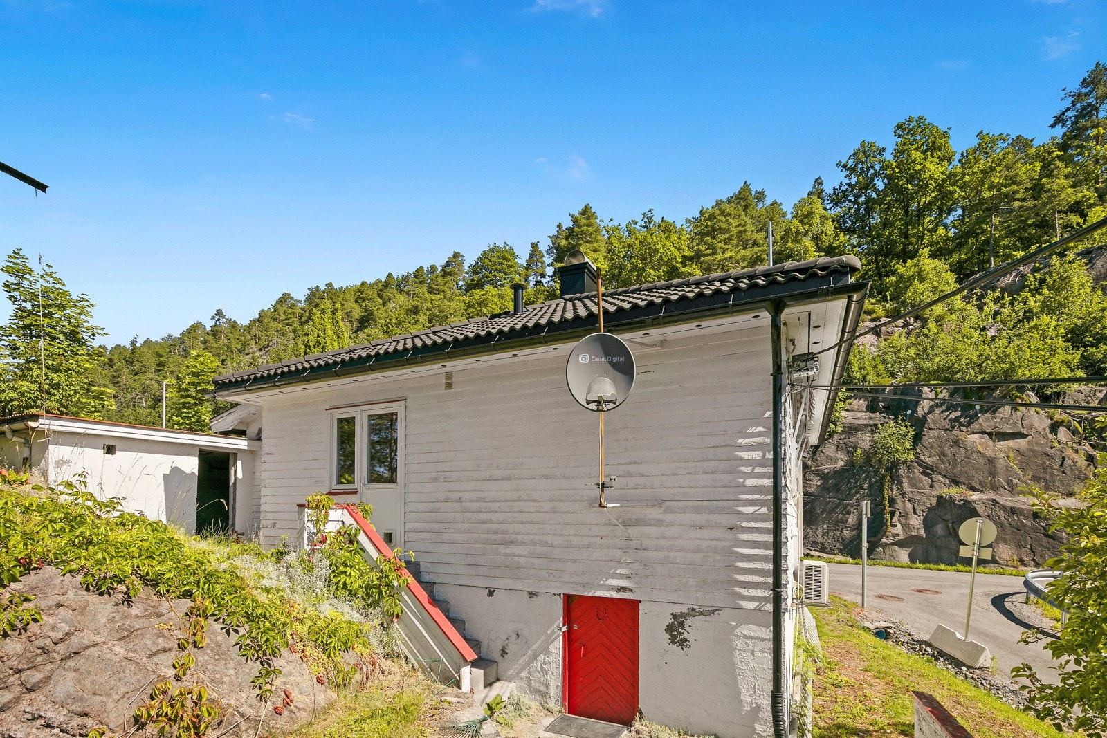 Uteområde med adkomst til underetasjen og trapp opp til kjøkkeninngangen Galleribilde