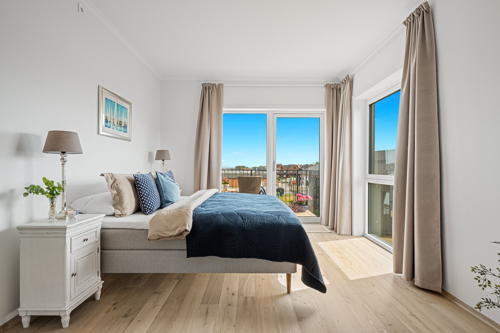 Store vindusflater og balkong gir hovedsoverommet et lyst preg, med moderne bad i tilknytning. Galleribilde