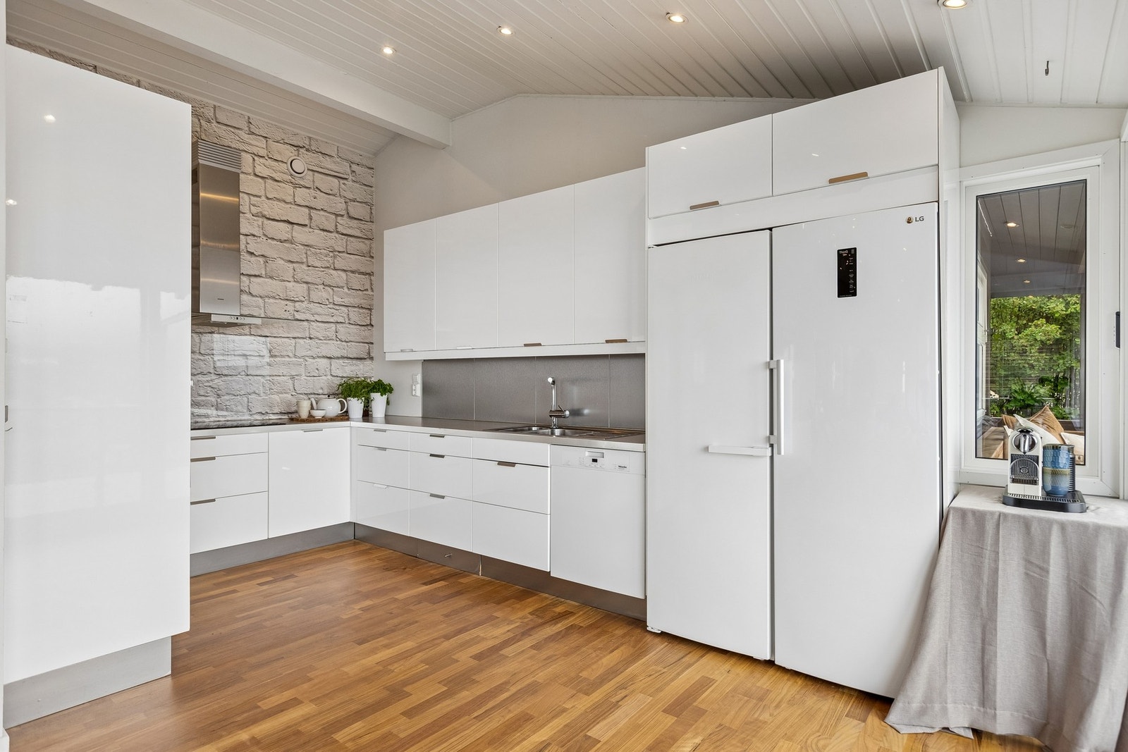 Stilrent og moderne kjøkken med gjennomført design, gode oppbevaringsløsninger og en innbydende atmosfære. Den åpne løsningen skaper en sosial og funksjonell ramme rundt både matlaging og samvær. Galleribilde