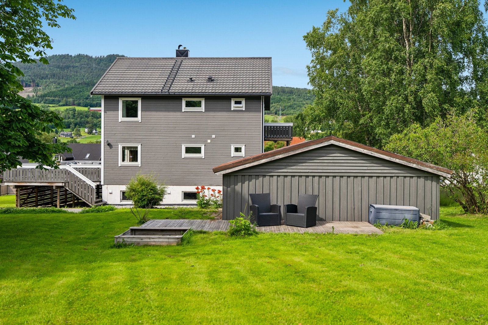 Boligen ligger fint tilbaketrukket på eiendommen, med grønt og åpent preg rundt huset. Galleribilde