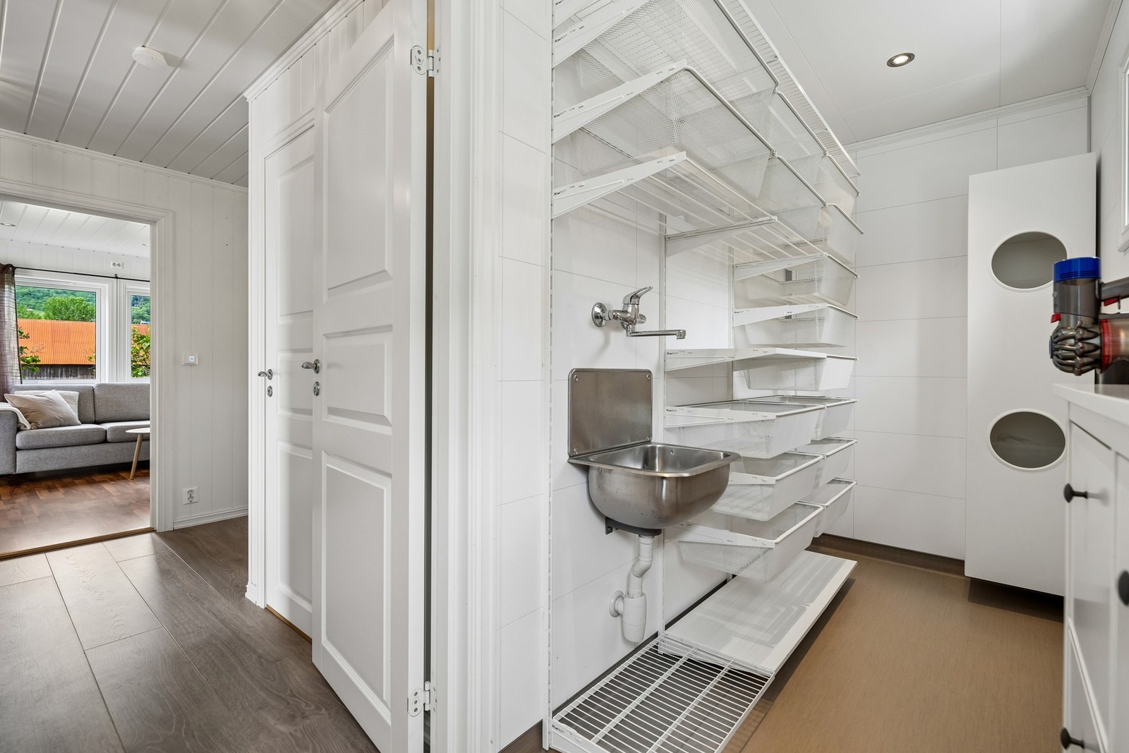 Praktisk vaskerom med innredning, arbeidsflate og plass til vaskemaskin. Galleribilde