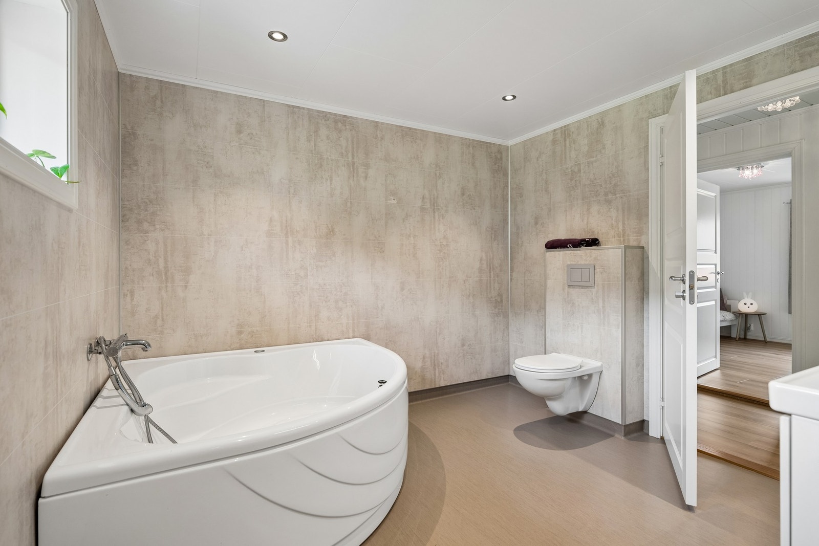 Badet har badekar, dusjnisje, vegghengt toalett og moderne innredning. Galleribilde