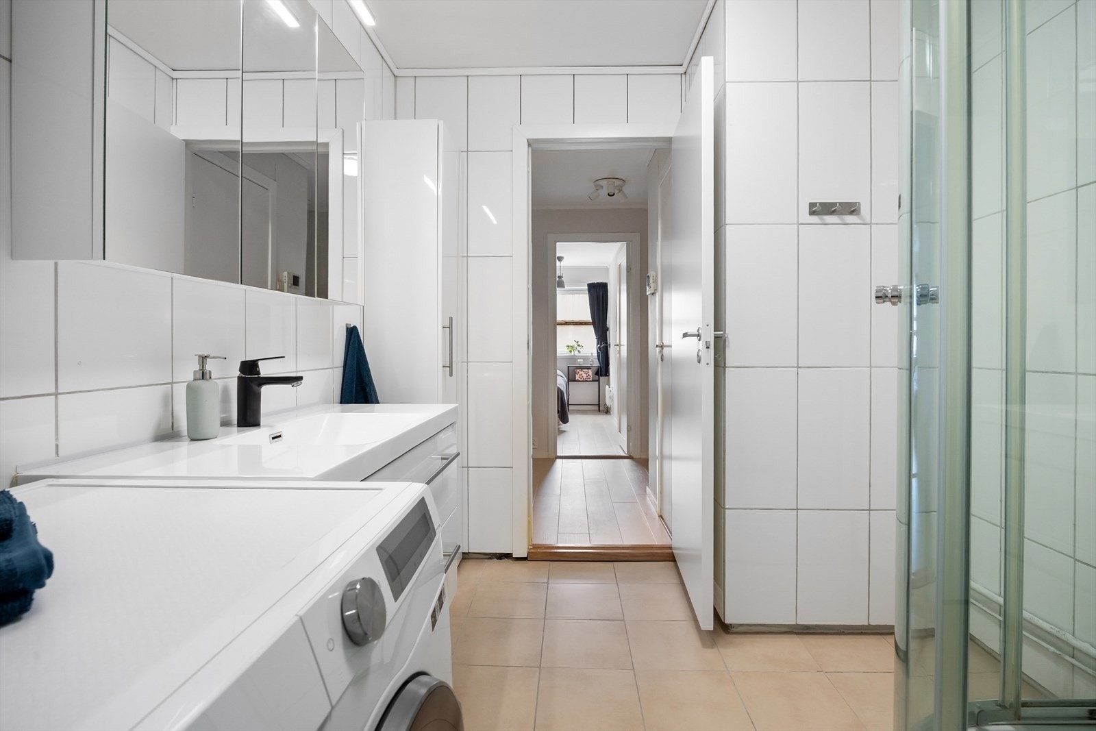 Badet er innredet servantskap med ett-greps blandebatteri, speilskap, høyskap og dusjkabinett. Galleribilde
