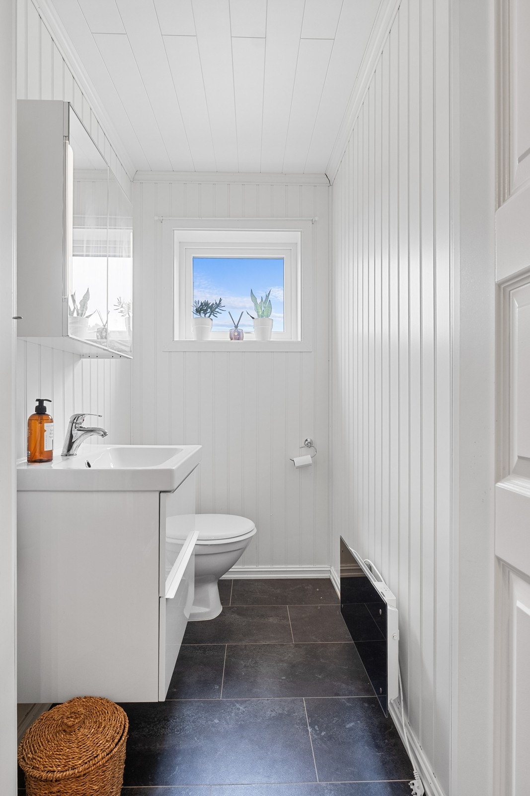 Toalettrom utstyrt med wc, servant m/ underskap og speilskap. Galleribilde