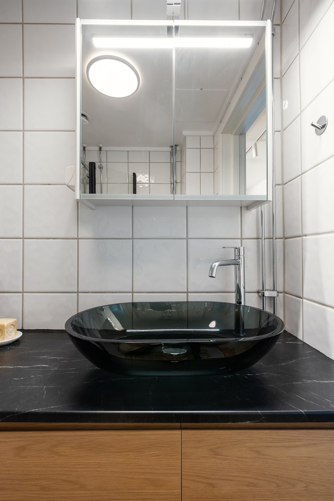 Badet er innredet med servantskap, servantbolle og speil med belysning fra 2024. Galleribilde