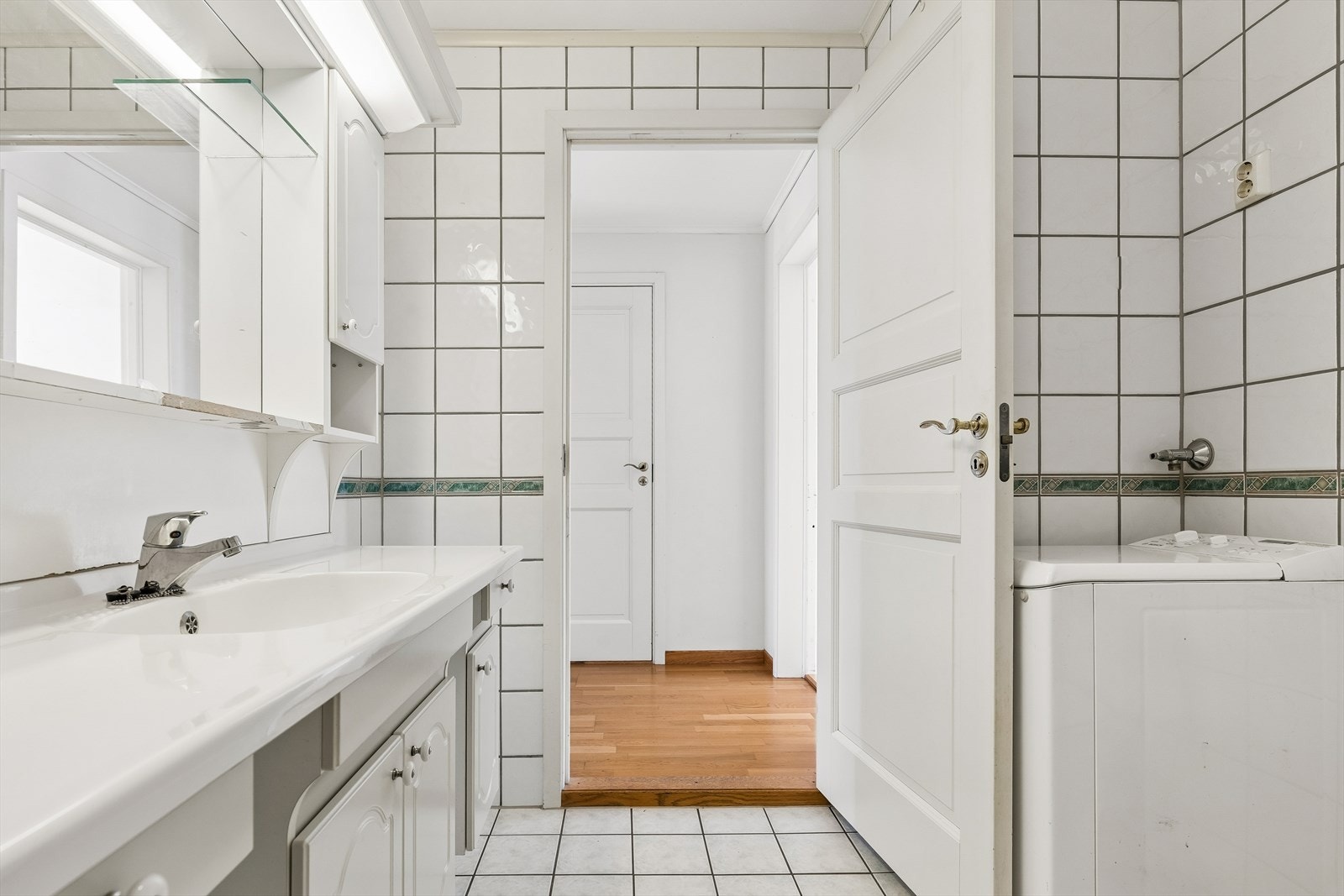 Badet har servantinnredning og opplegg for vaskemaskin. Galleribilde