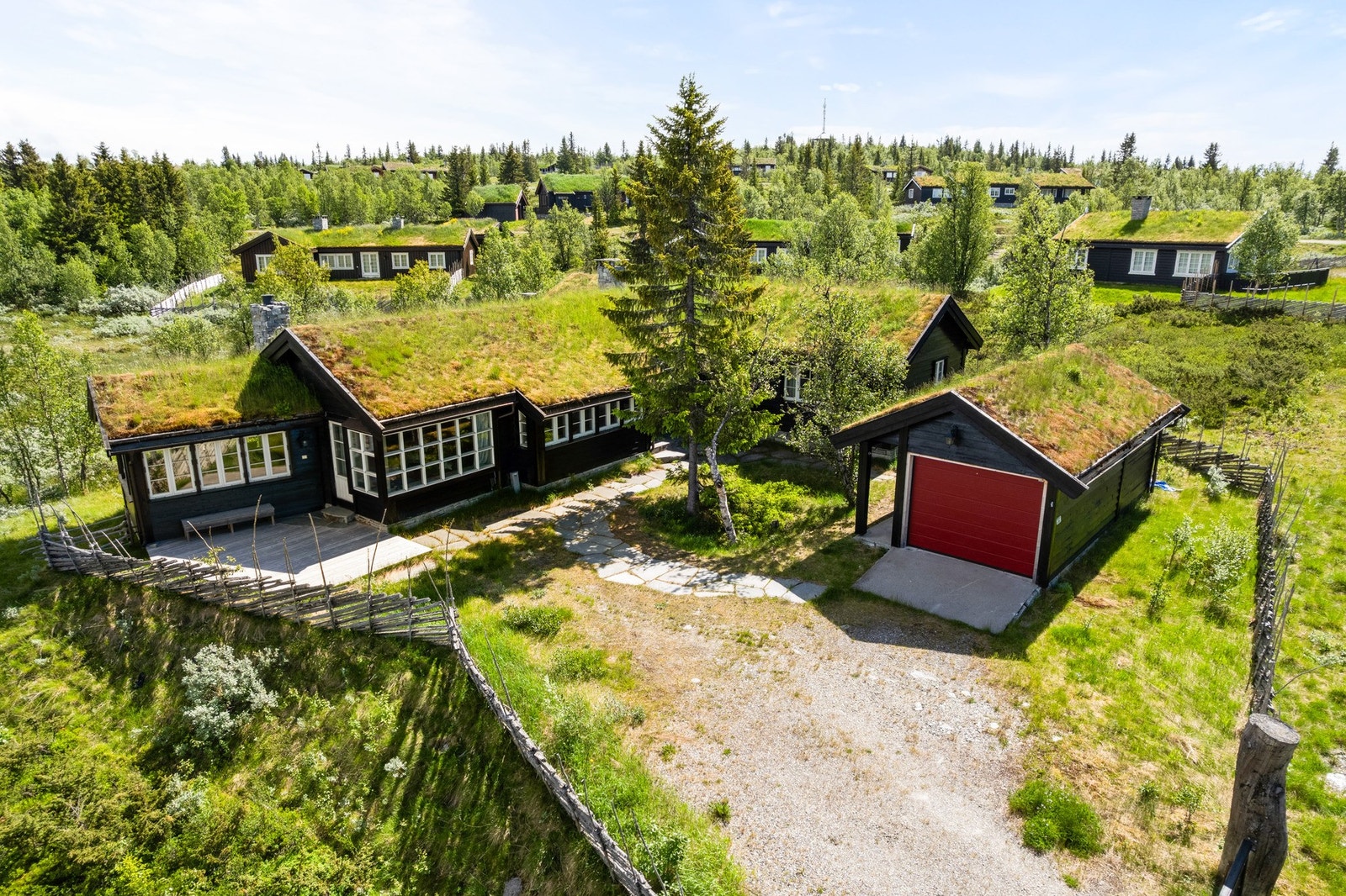 Eiendommen er svært pent opparbeidet, og mellom inngangspartiet, terrassen på fremsiden av hytta og garasjen er det lagt skiferheller som skaper et helhetlig og svært innbydende uttrykk. Galleribilde