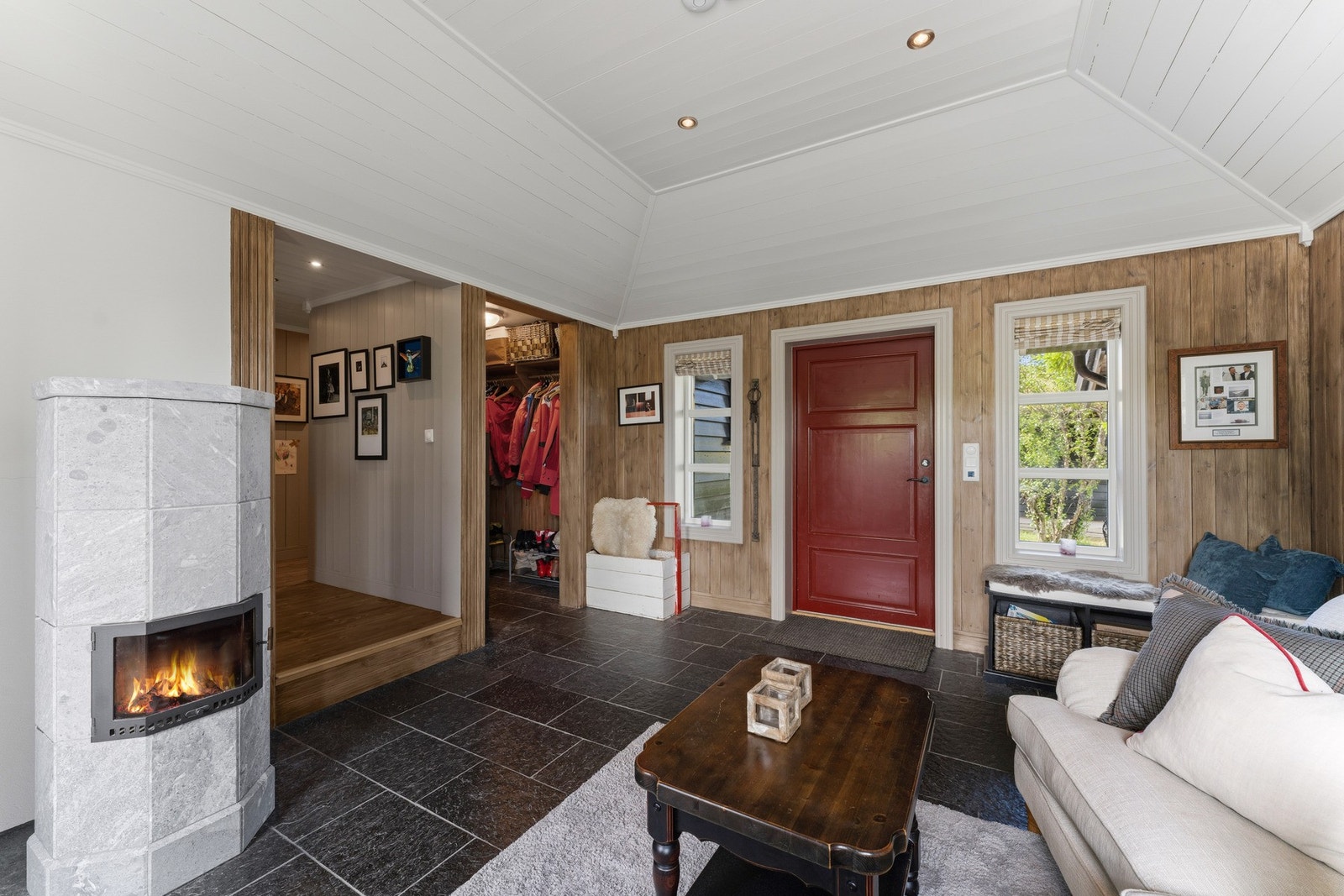 Du ønskes velkommen inn i en romslig og innbydende entré med flislagt gulv og panel på vegger og i himling. Galleribilde