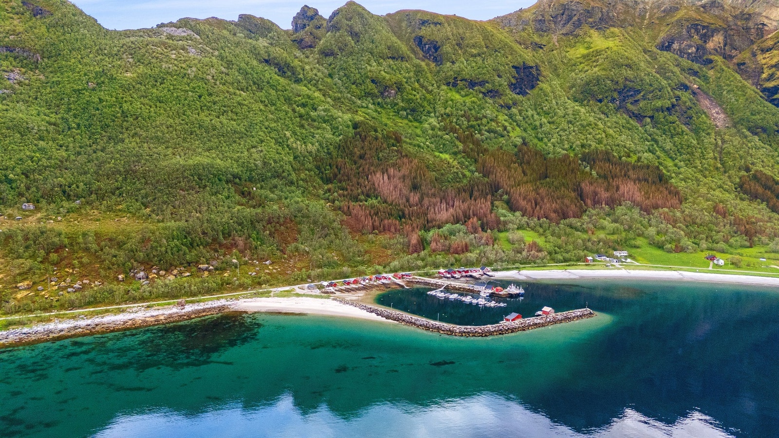 Fjorden speilblankt og fjellene rett opp. Naustklyngen i Storvik ligger der den har ligget i generasjoner, men det røde naustet er nå innredet fra topp til bunn. Galleribilde