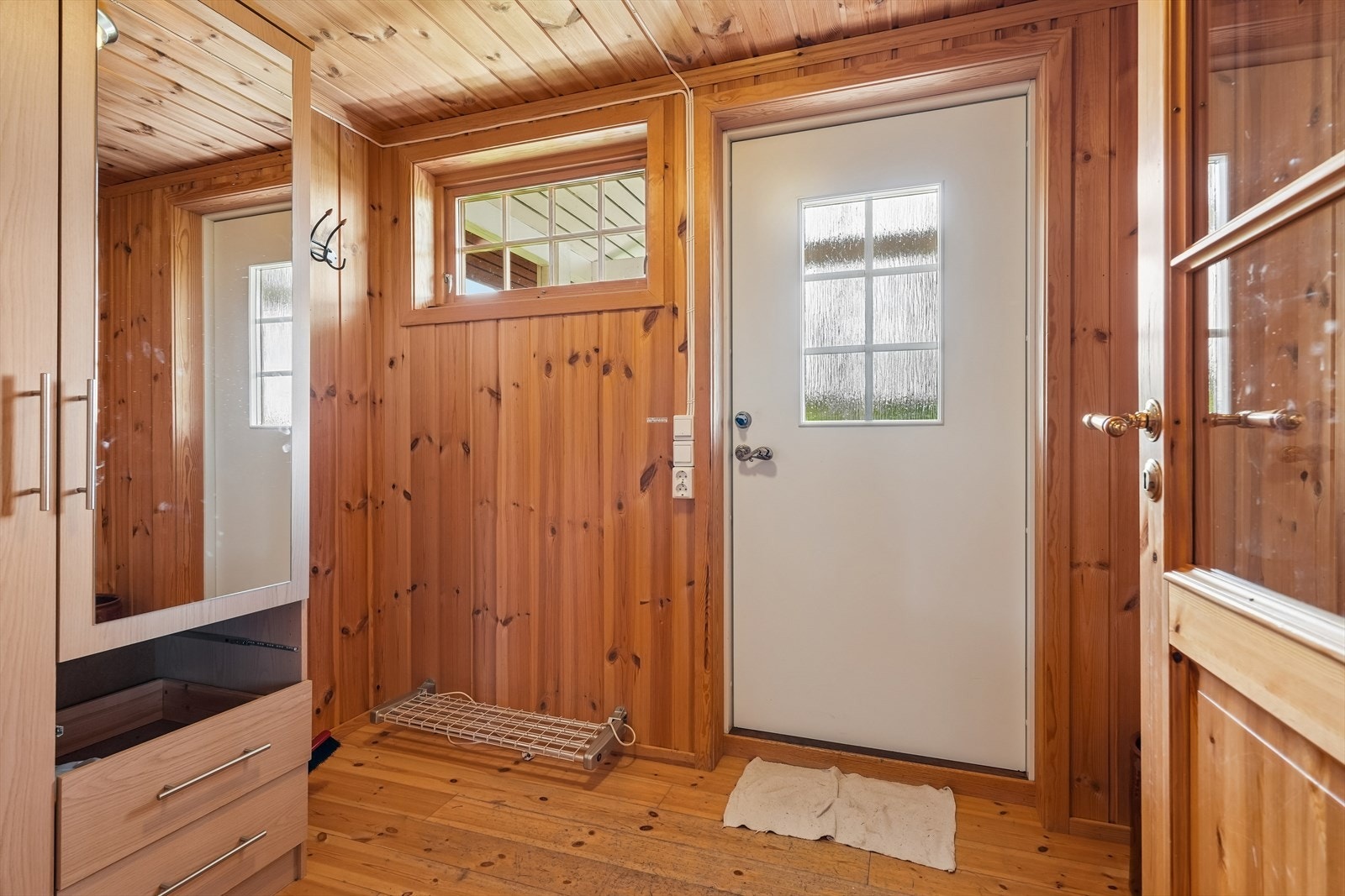 Fra verandaen kommer du inn i en romslig entré med garderobeskap og god plass til oppbevaring av yttertøy og sko. Galleribilde