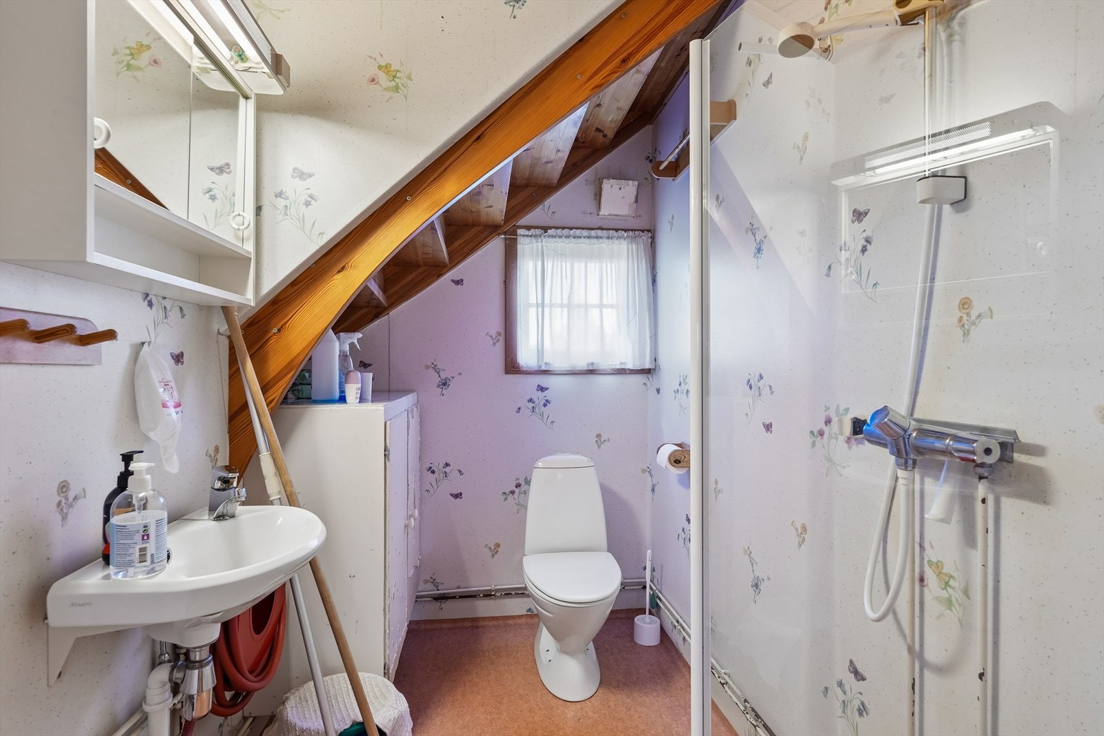 Badet ligger i hovedetasjen og er av enkel standard. Rommet har belegg på gulv med varmekabler. Innredningen består av veggmontert dusj med glassdør på én side, servant og gulvstående toalett. Galleribilde