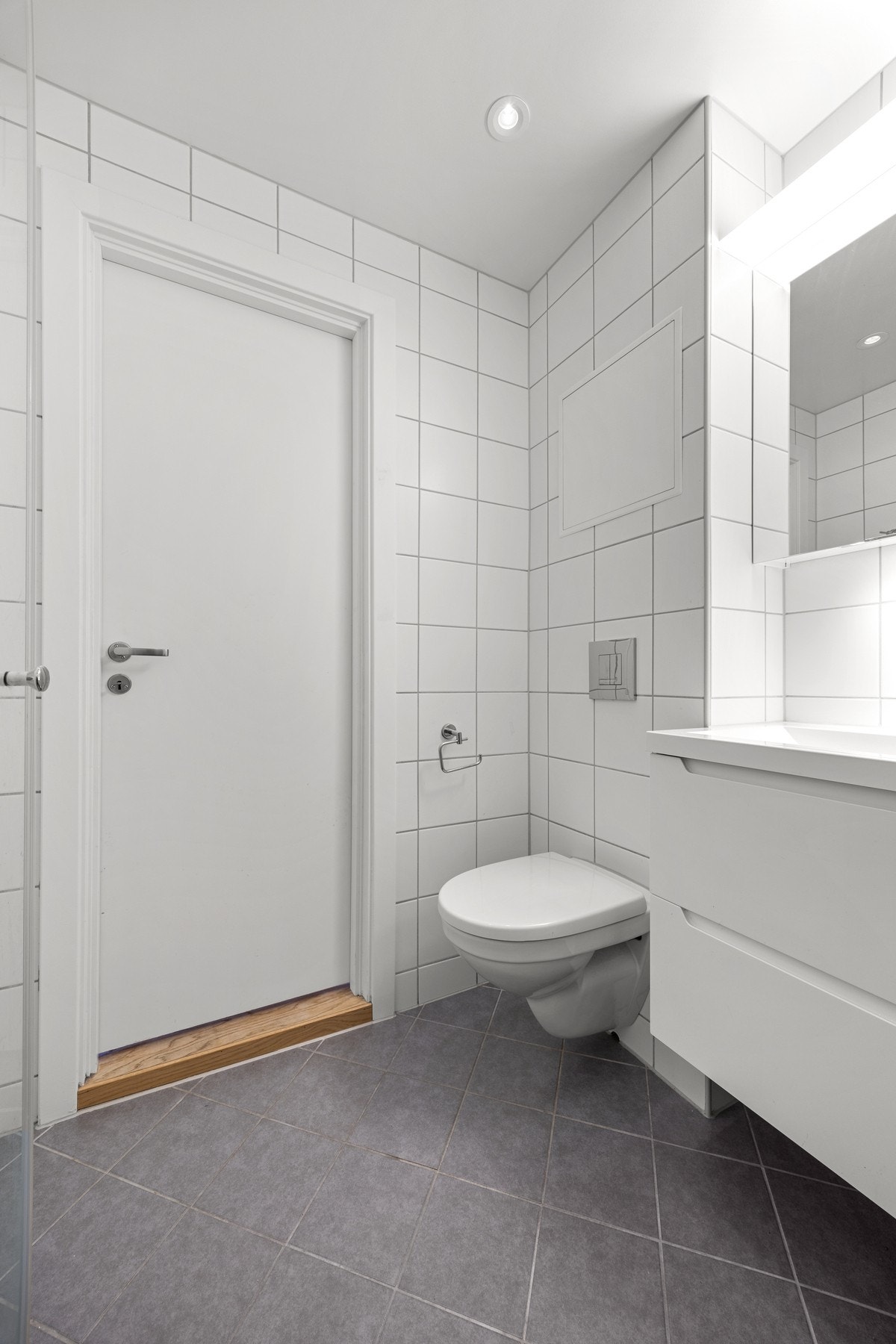 Vegghengt toalett, flislagte overflater og downlights i tak Galleribilde