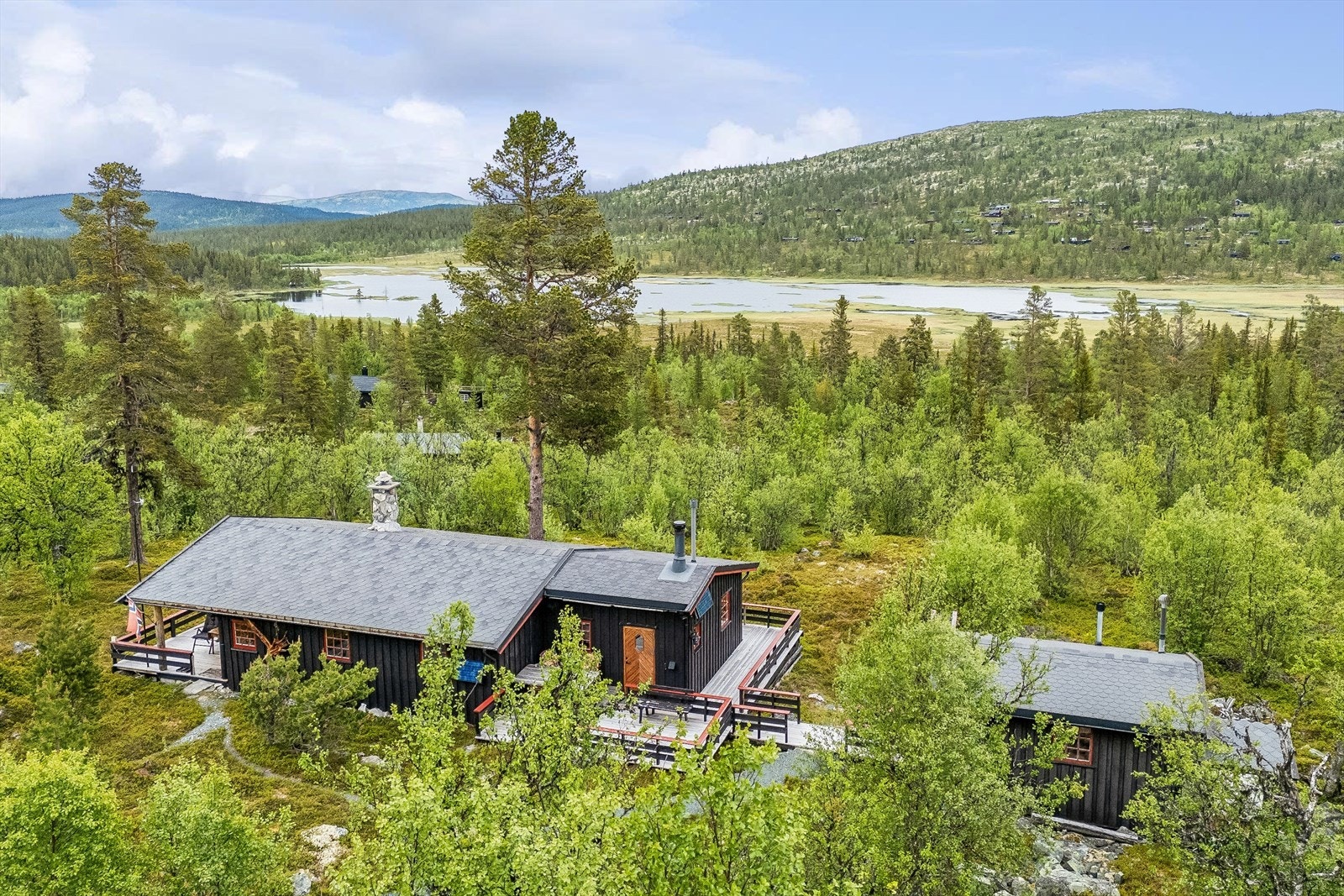 Hyttas usjenerte plassering i det rolige og naturskjønne landskapet. Galleribilde