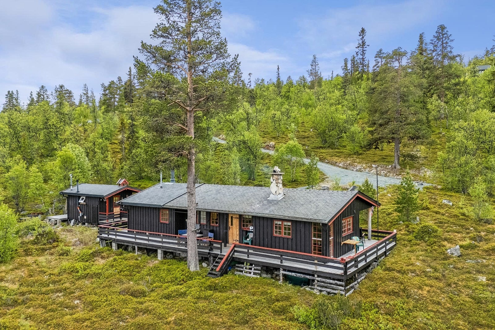 Eiendommen består av hovedhytte og et frittstående uthus, forbundet med en gangbro. Galleribilde
