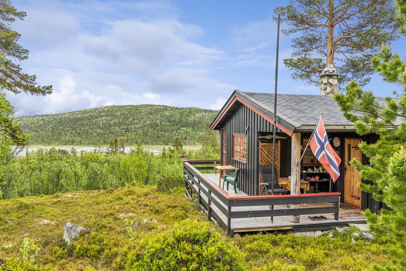 Fritidsbolig fra 1973, beliggende på en åpen naturtomt med stedbunden vegetasjon. Galleribilde