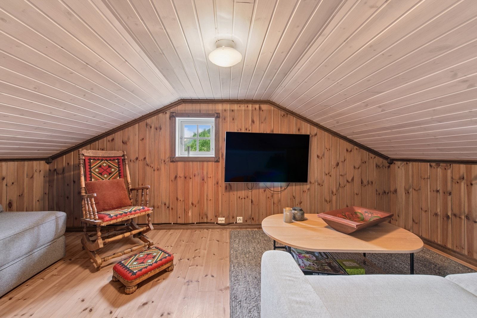Koselig loftstue innredet med sofa og TV - et perfekt sted å trekke seg tilbake for rolige kvelder, filmkos, spill og hyggelige stunder med familie og venner. Galleribilde