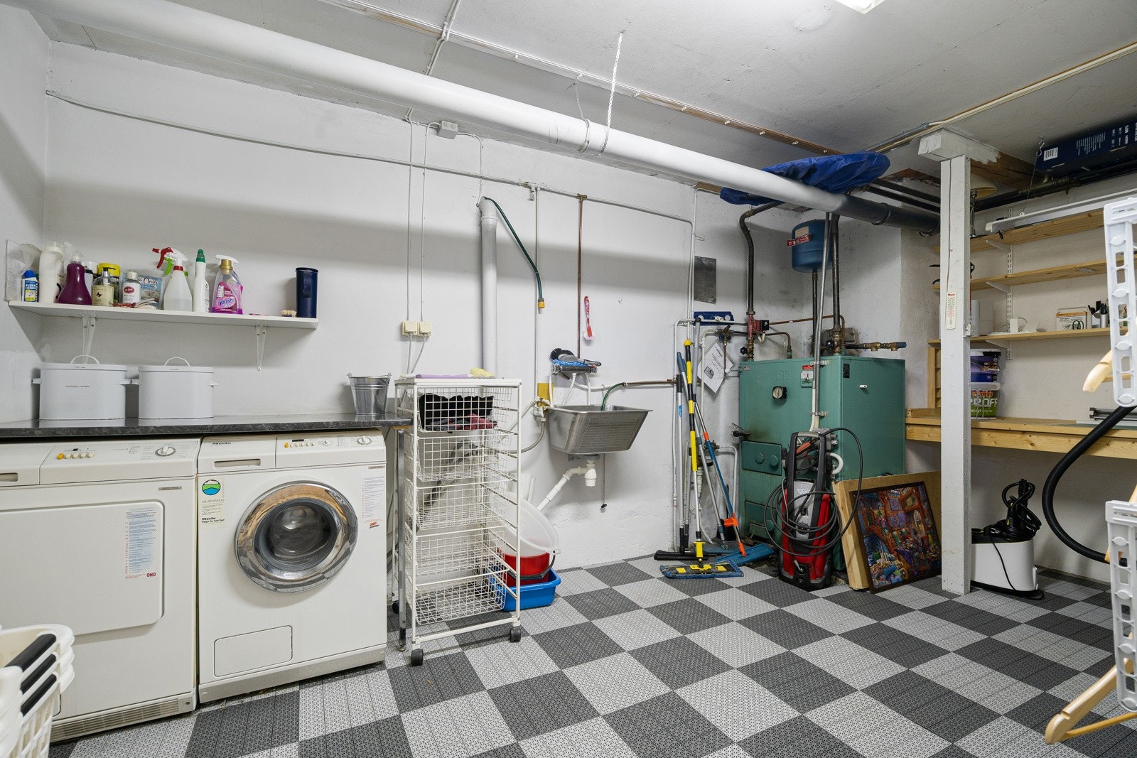 Vaskerom med med skyllekum, hyller for oppbevaring og opplegg for vaskemaskin