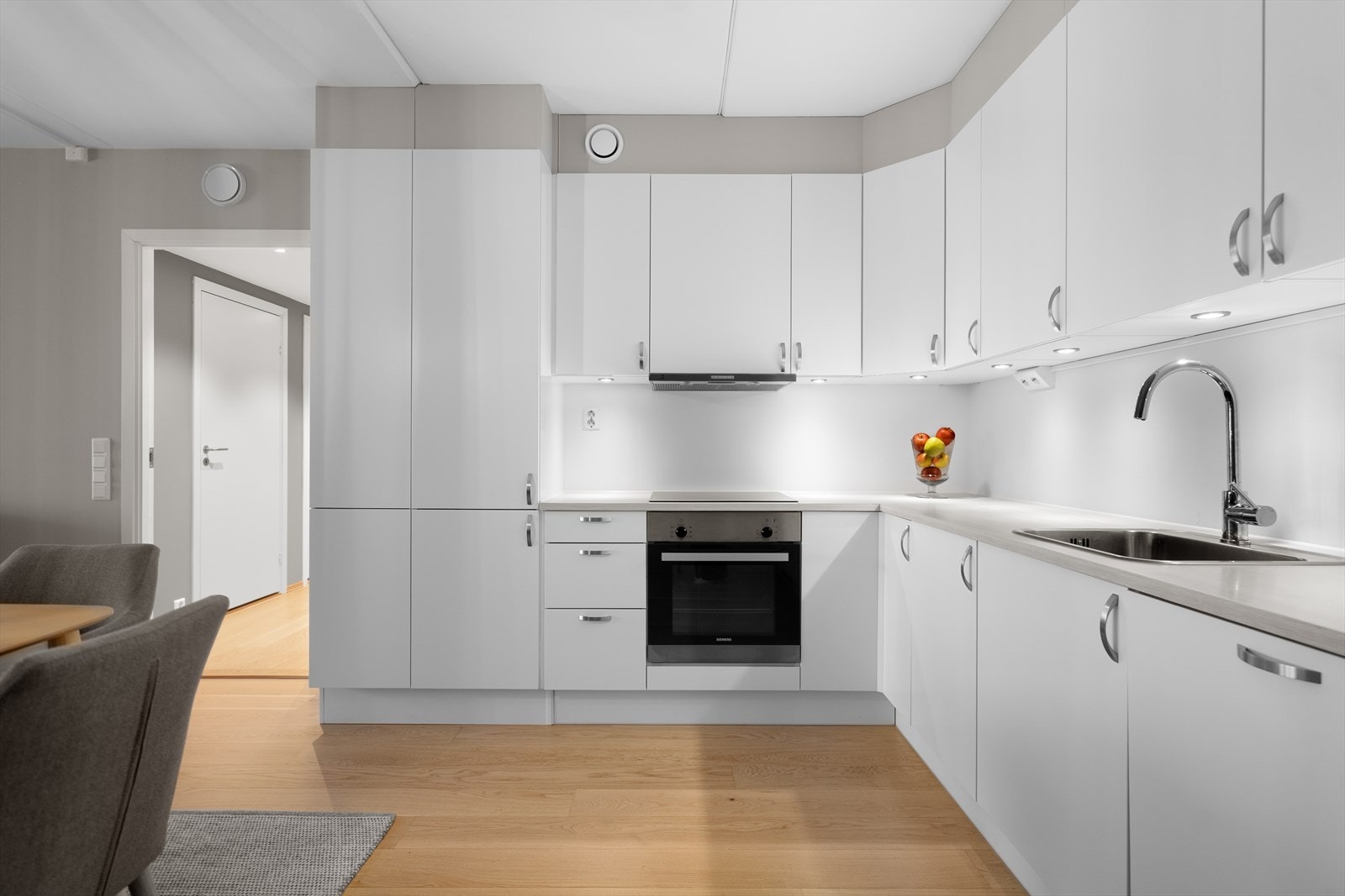 Kjøkkenet har integrerte hvitevarer - kjøl/frys, stekeovn, koketopp, ventilator og oppvaskmaskin - samt rikelig med oppbevaring og god benkeplass. Galleribilde