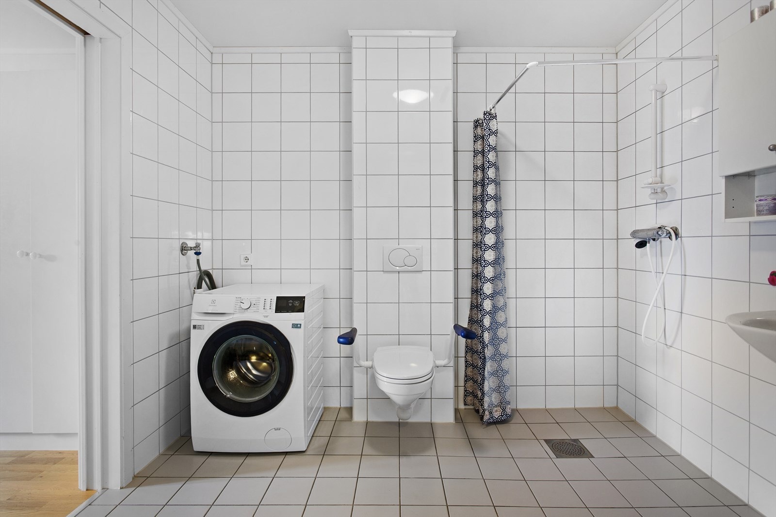 Flislagt bad med vegghengt wc, dusjhjørne med forheng, servant med speil og overskap. Opplegg for oppvaskmaskin. Galleribilde