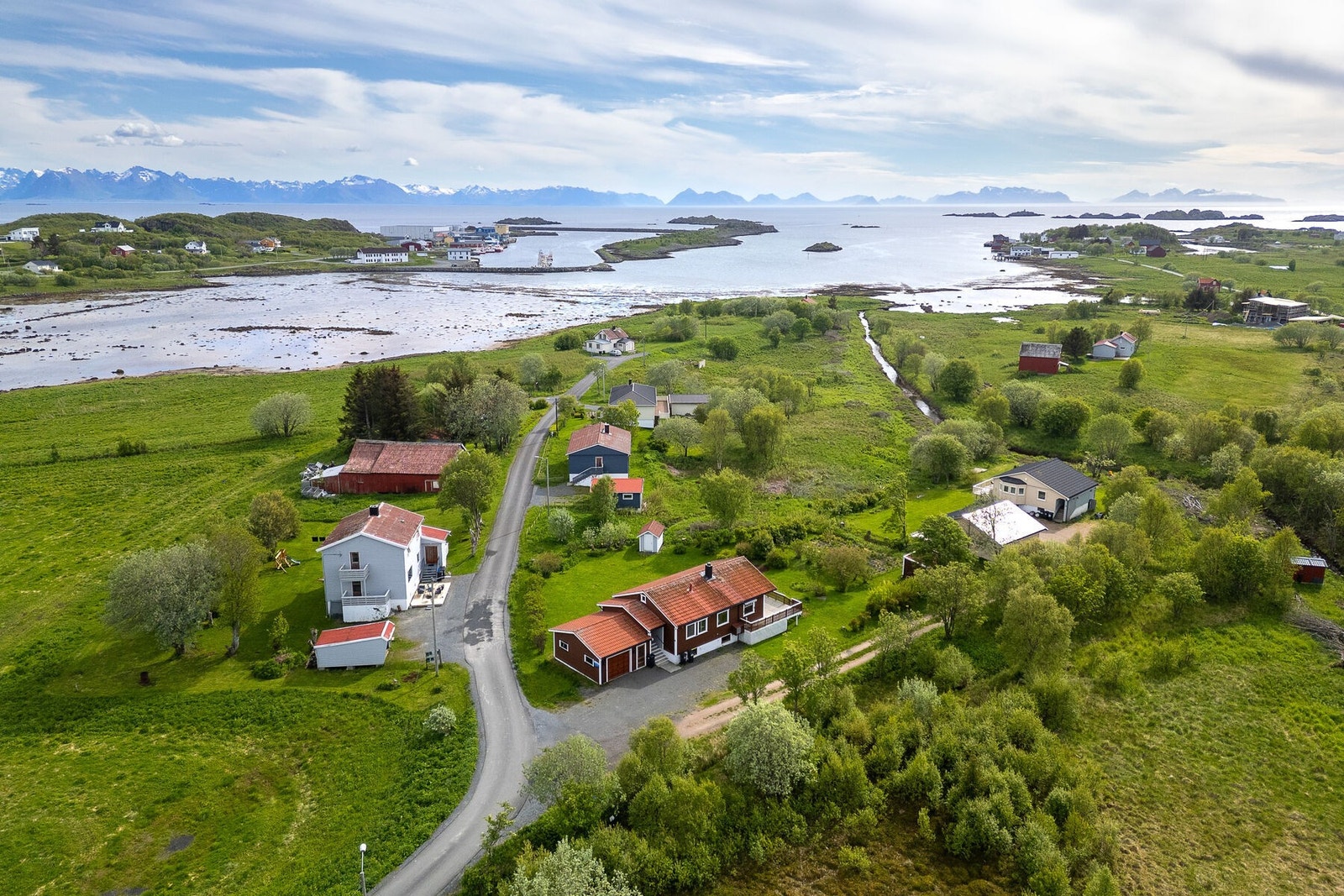 Eiendommen ligger på en tilnærmet flat tomt opparbeidet med plen og gruset innkjøring. Galleribilde