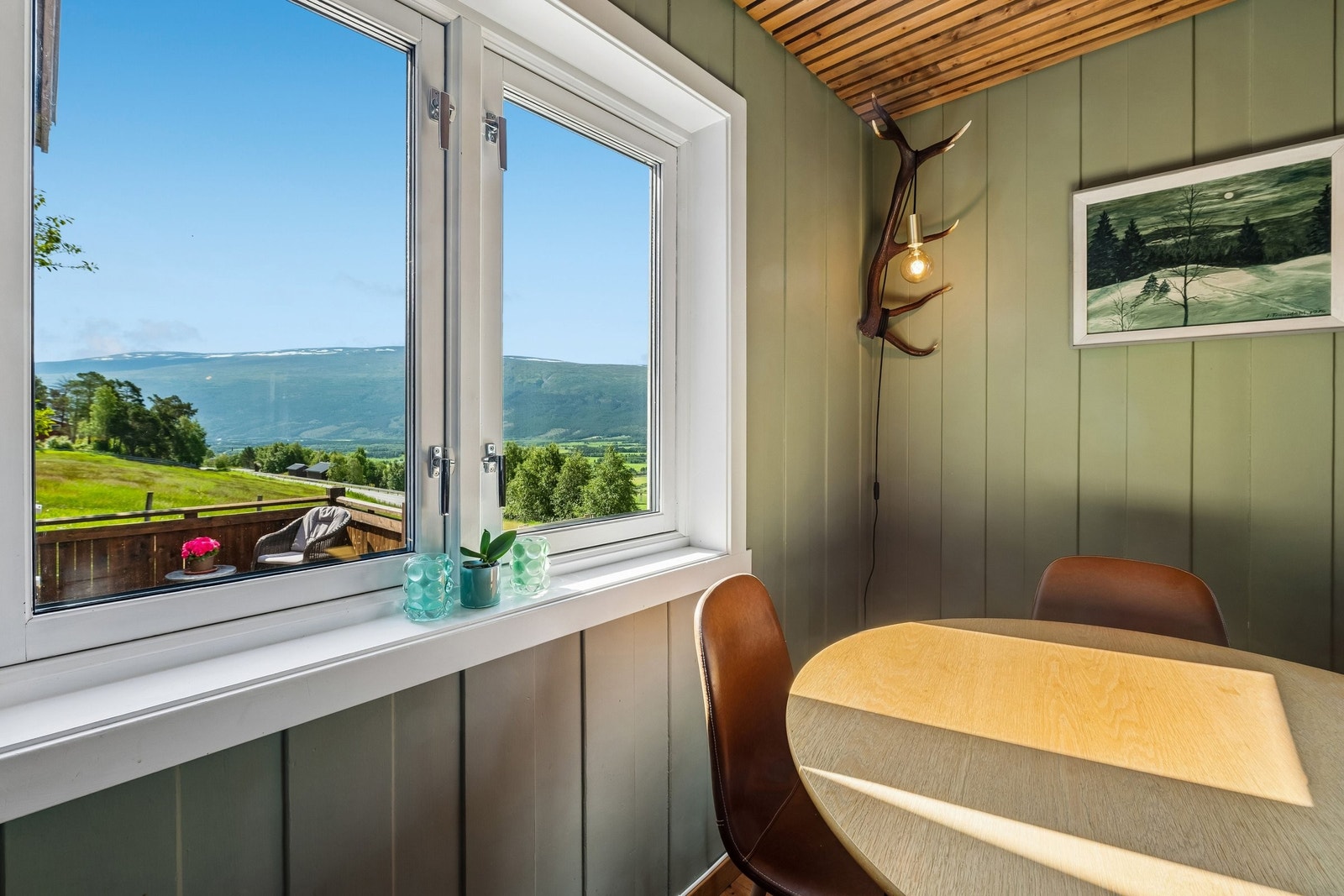 Utsyn over terrasse og innmarka på østsiden av huset. Galleribilde