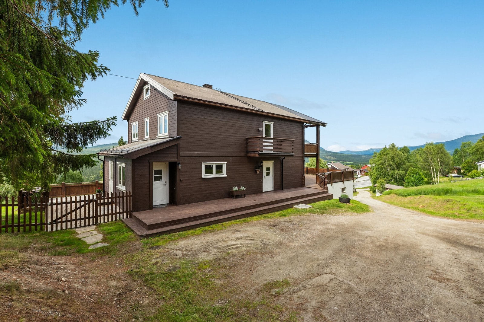 Fasade mot nord. Inngang til begge boenhetene. Grind til inngjerdet område på nedsiden av huset. Galleribilde