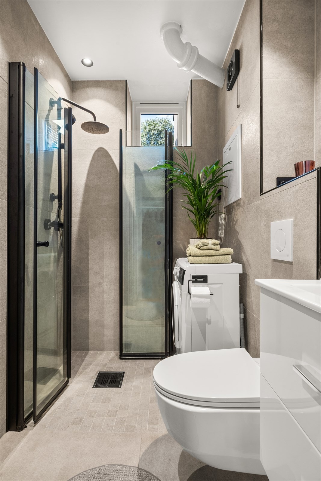 Det moderne badet fra 2022 har tidsriktige, flislagte overflater, innfelte downlights i himling og behagelig gulvvarme. Det er opplegg for vaskemaskin. Galleribilde