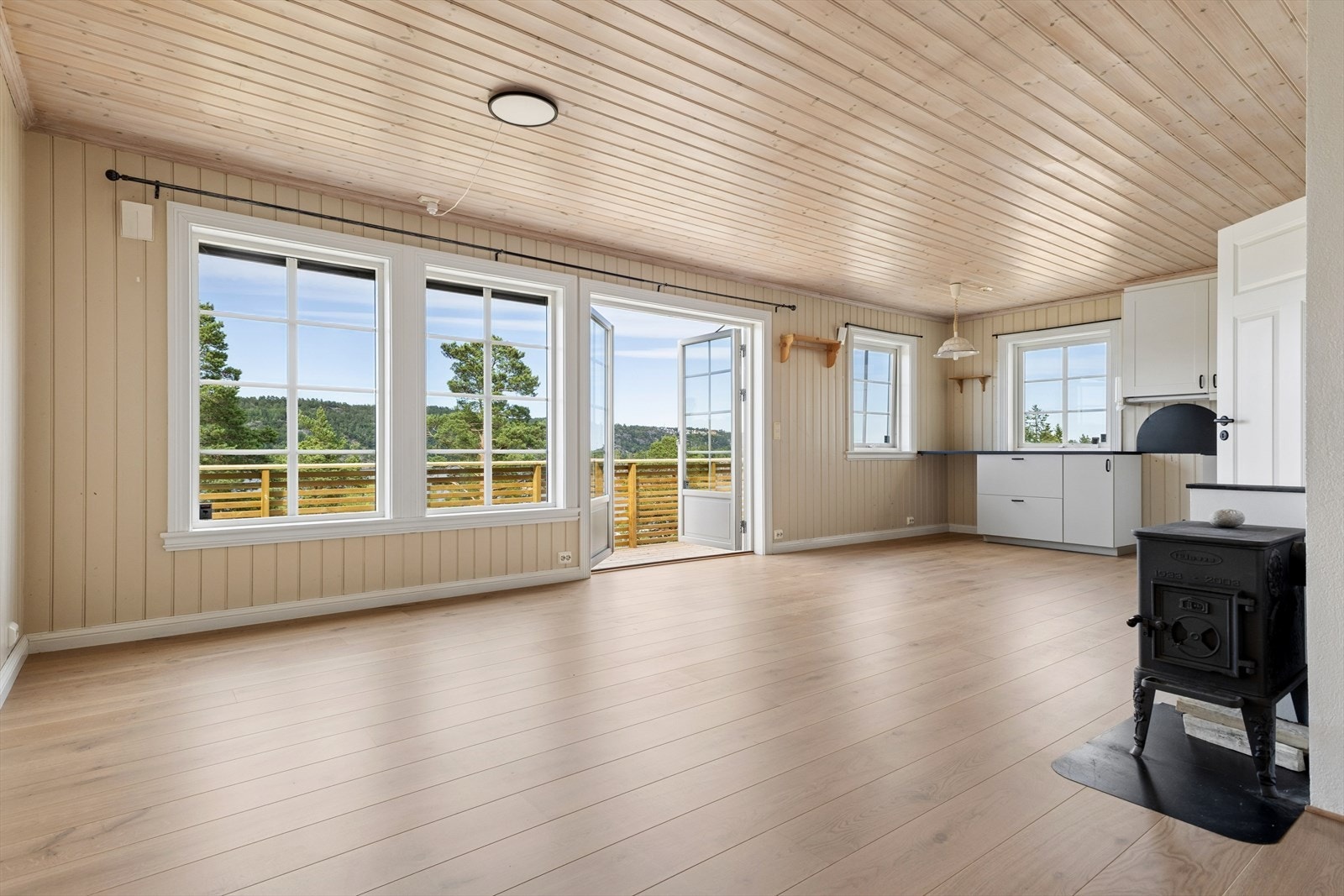 Boligens sosiale sone med stue og kjøkken ligger i åpen løsning. Et lyst og innbydende oppholdsrom med store vindusflater som sørger for rikelig med lysinnslipp, samtidig som de slipper inn den flotte utsikten. Galleribilde