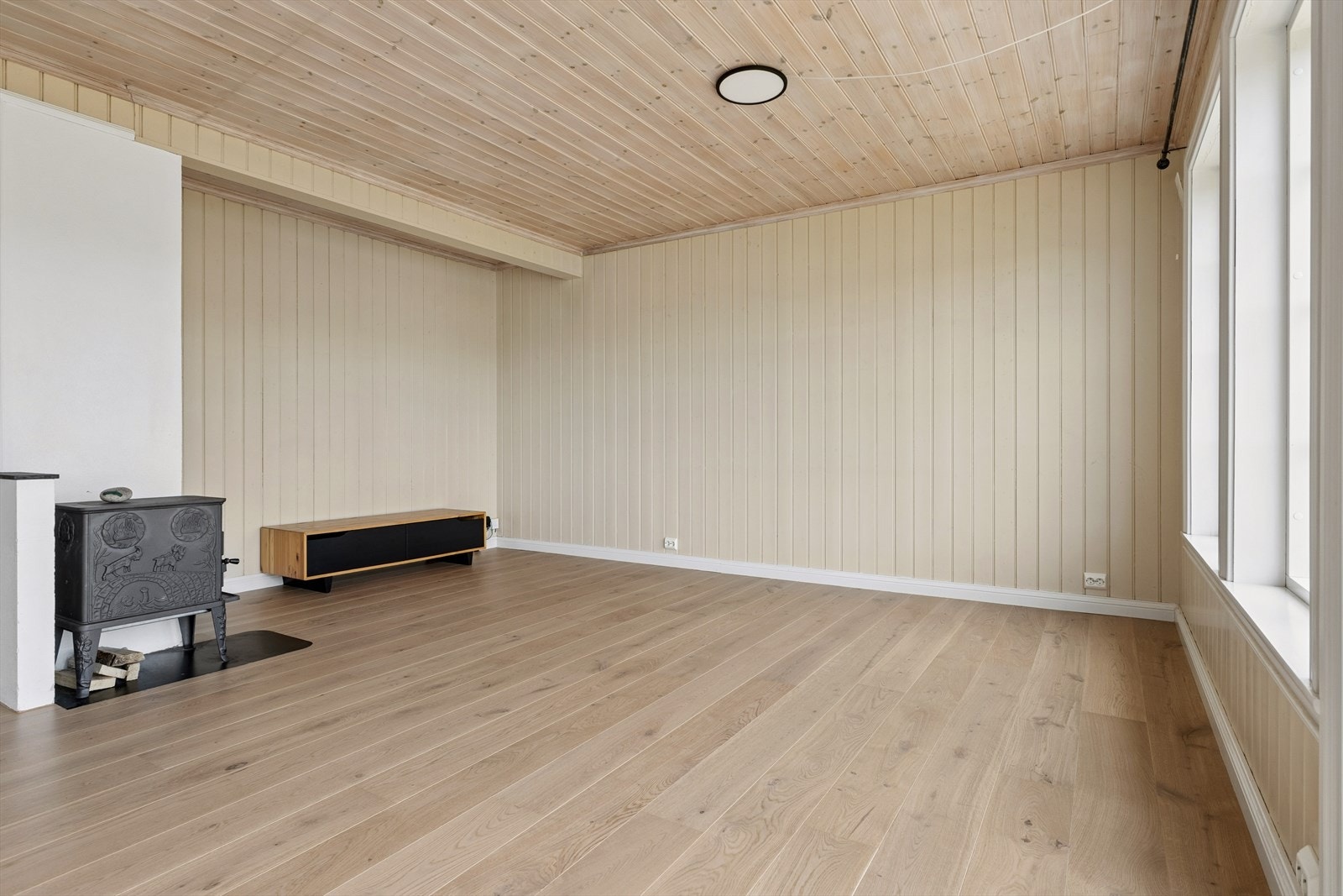 Rommet gir god plass til møblement i flere soner og er utstyrt med en vedovn som sørger for god varme på kalde dager. Galleribilde