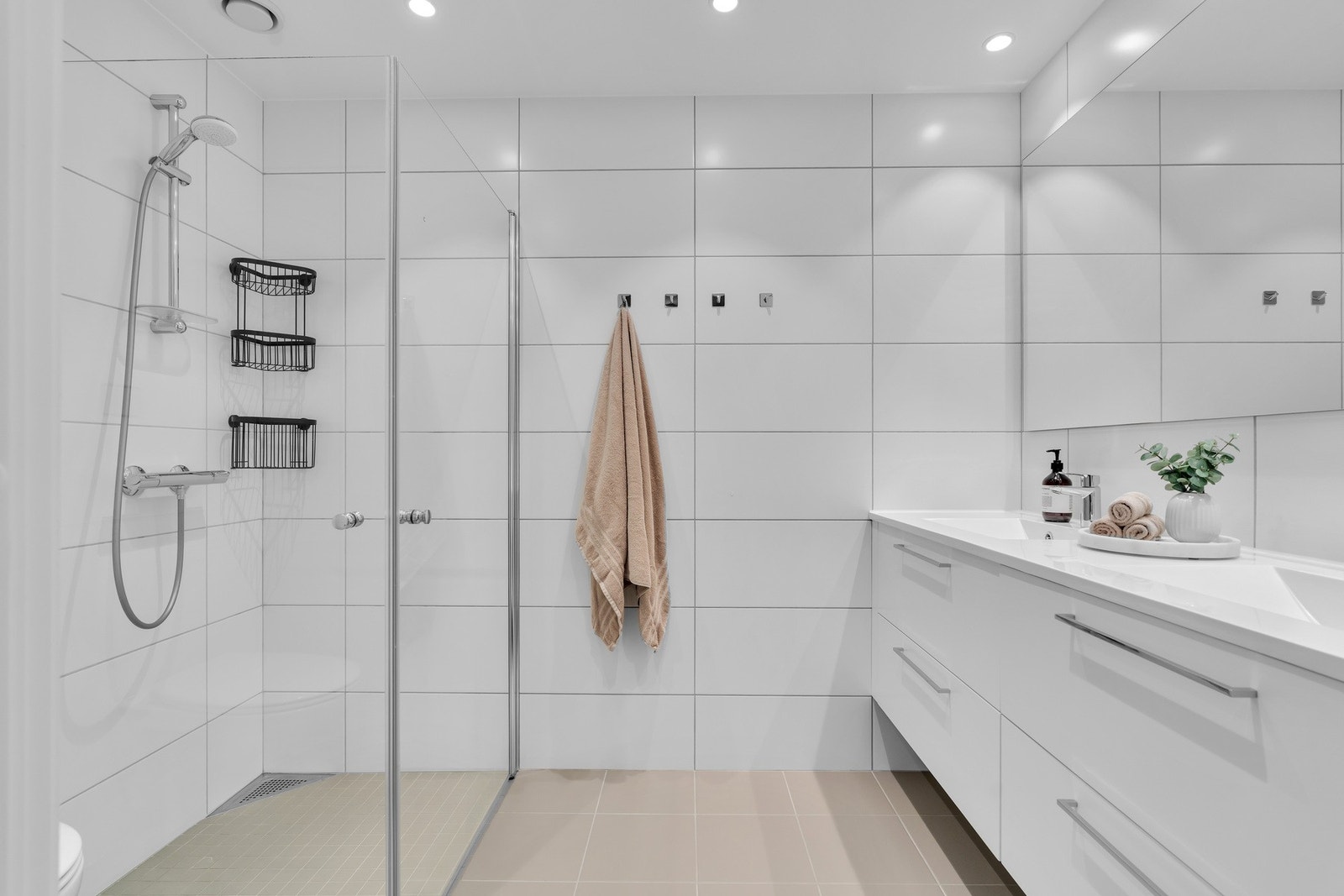 Dette badet er romslig og har dobbel servant, dusjhjørne og moderne vegghengt toalett. Galleribilde