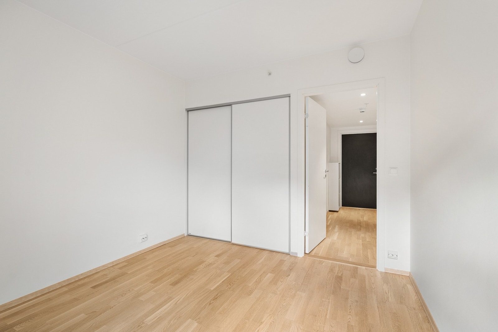 En stor skyvedørsgarderobe gir rikelig med oppbevaringsplass på soverommet. Galleribilde