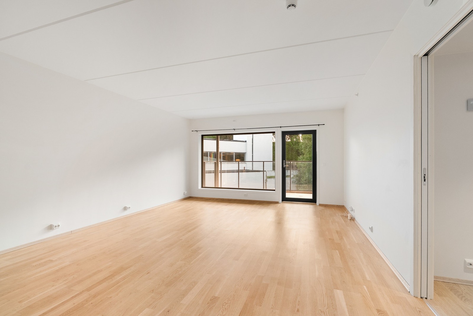 Store vindusflater gir rikelig med naturlig lys inn i stuen. Galleribilde