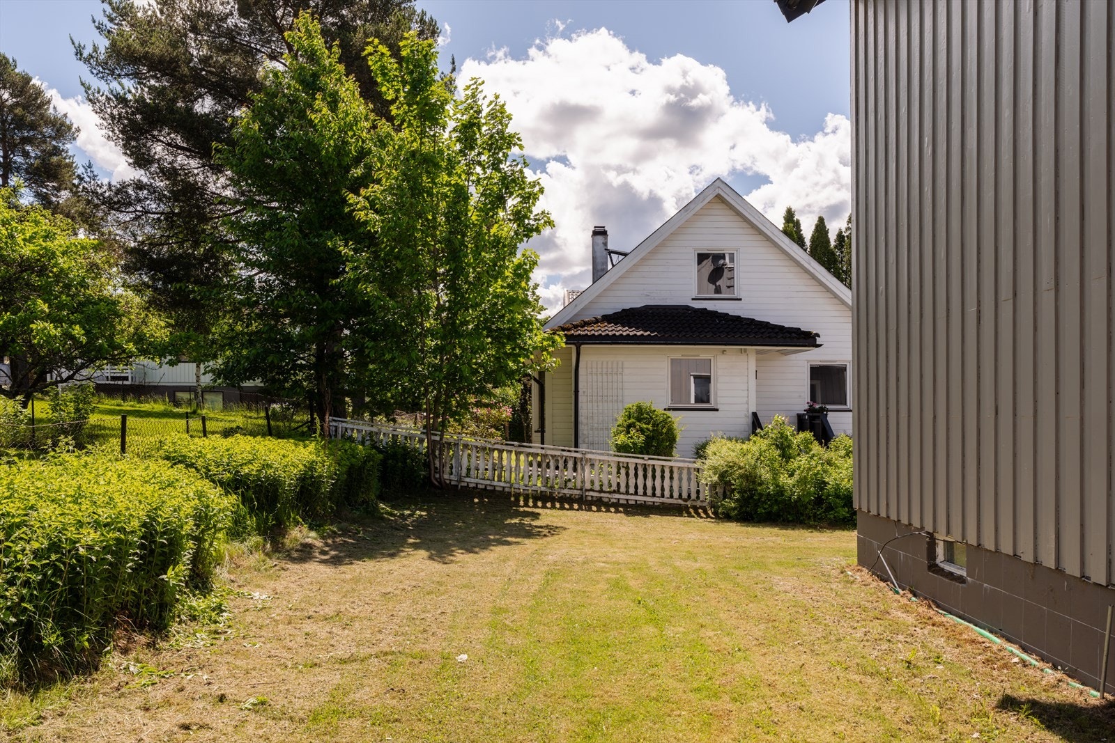 Hagen er opparbeidet med gressplen og beplantning. Galleribilde