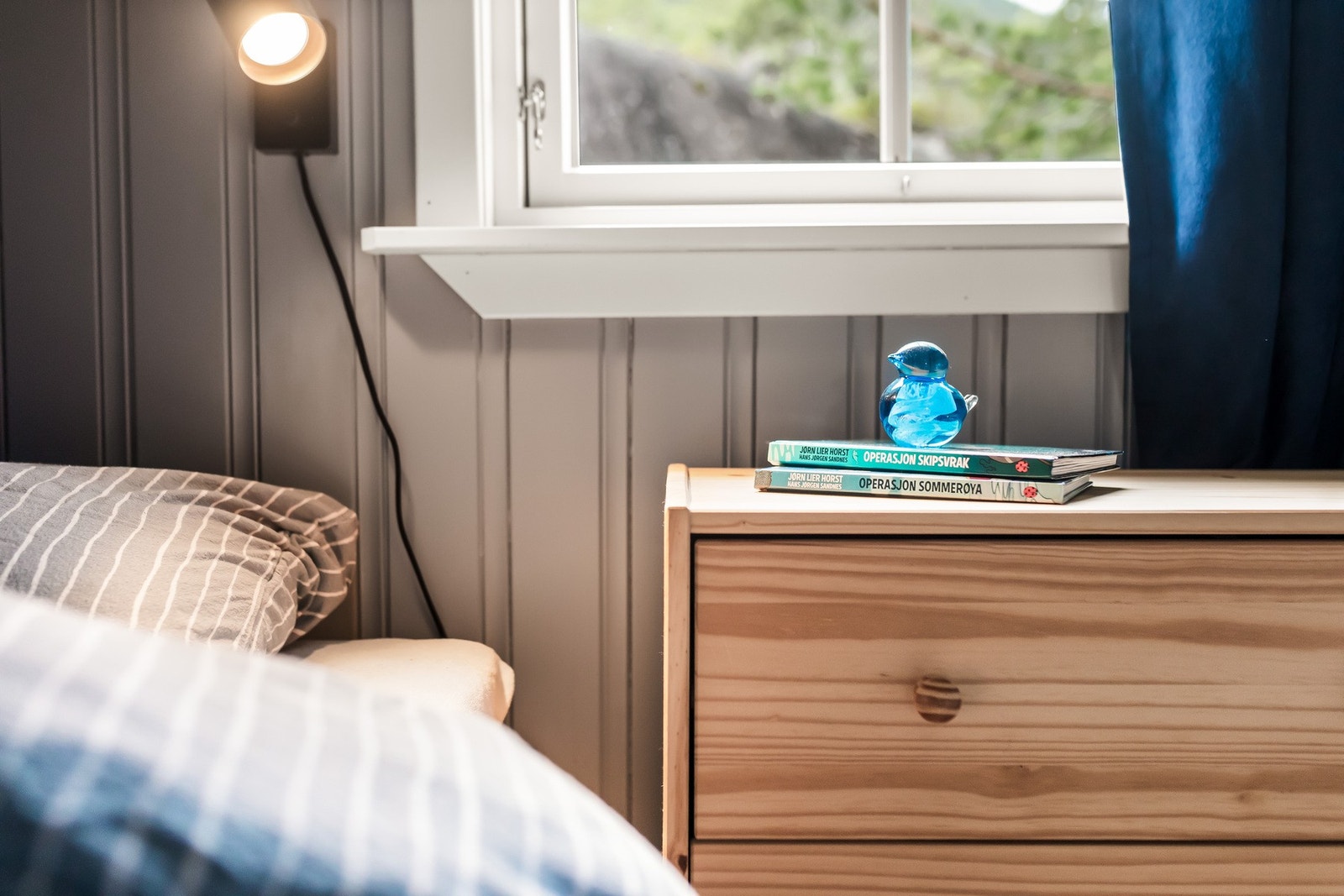 Soveromet har gulvbord av tre og overflatebehandlet trepanel på vegger og tak, noe som gir et lunt uttrykk. Galleribilde