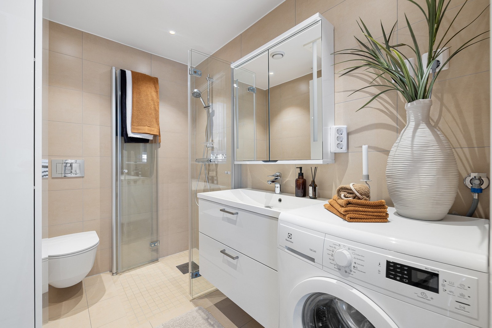 Badet er utstyrt med varme i gulv, innfellbare dusjvegger i glass og opplegg til vaskemaskin. Galleribilde