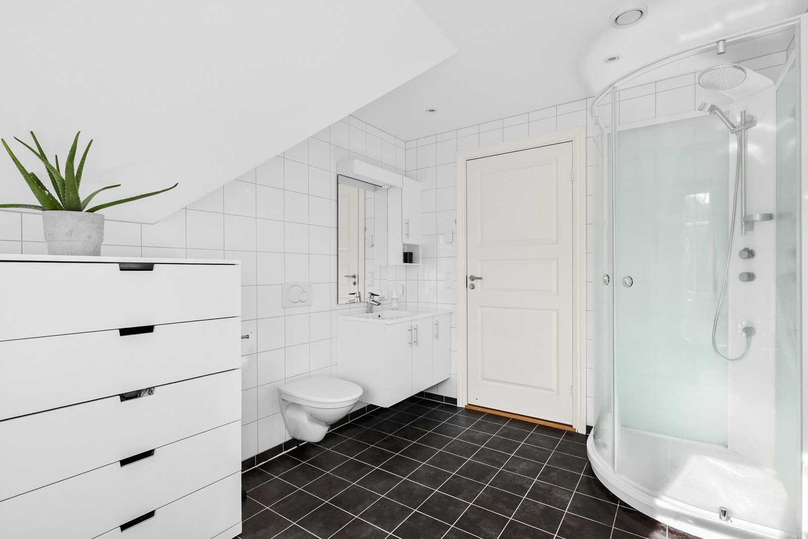 Bad i loftsetasje med baderomsinnredning, dusjkabinett, badekar og vegghengt toalett Galleribilde