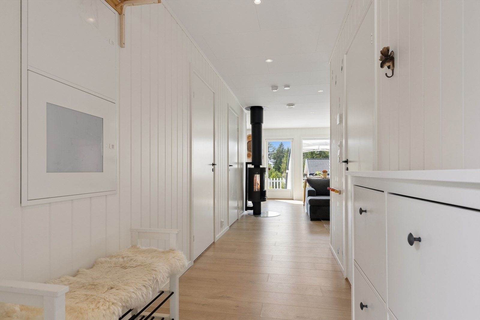 Gjennomgående laminatgulv og vegger med panelplater skaper en helhetlig stil. Galleribilde