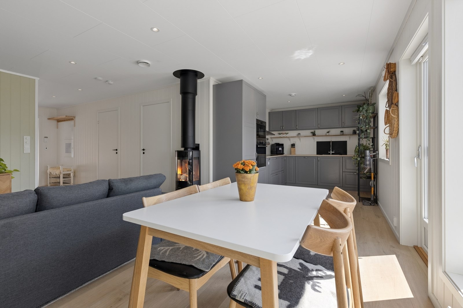 Stuen har plass til både spisebord og sofagruppe, og en peisovn for ekstra varme. Galleribilde