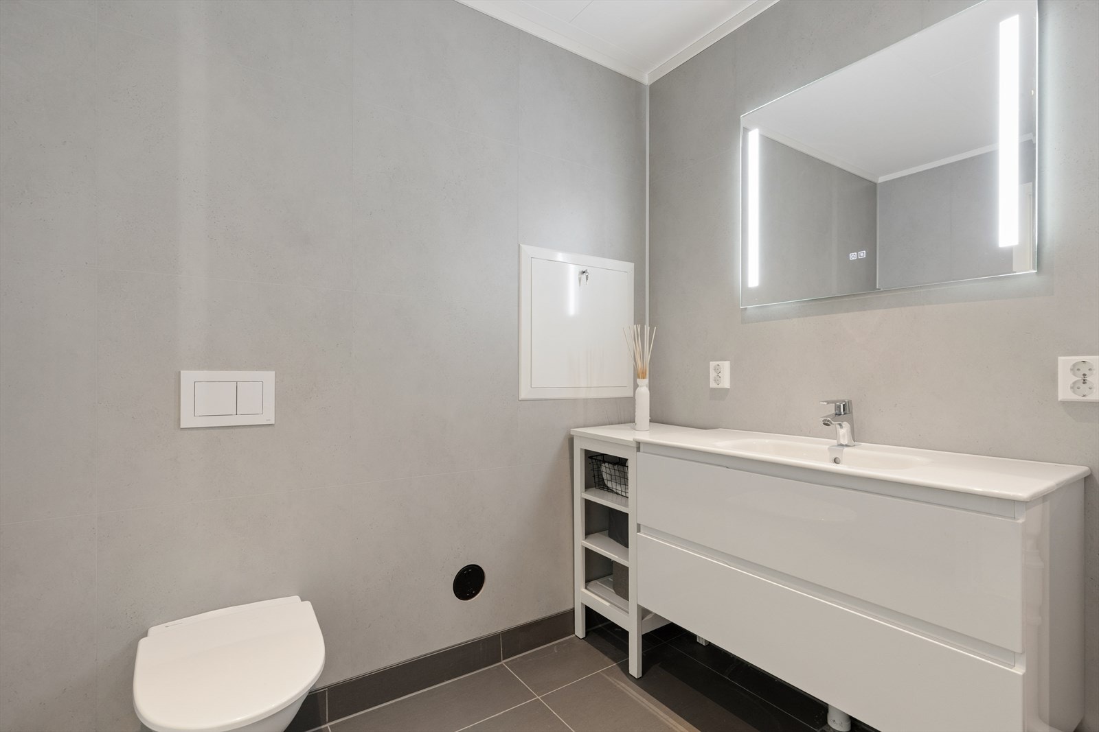 Badet er utstyrt med vegghengt toalett og baderomsplater på vegg. Galleribilde