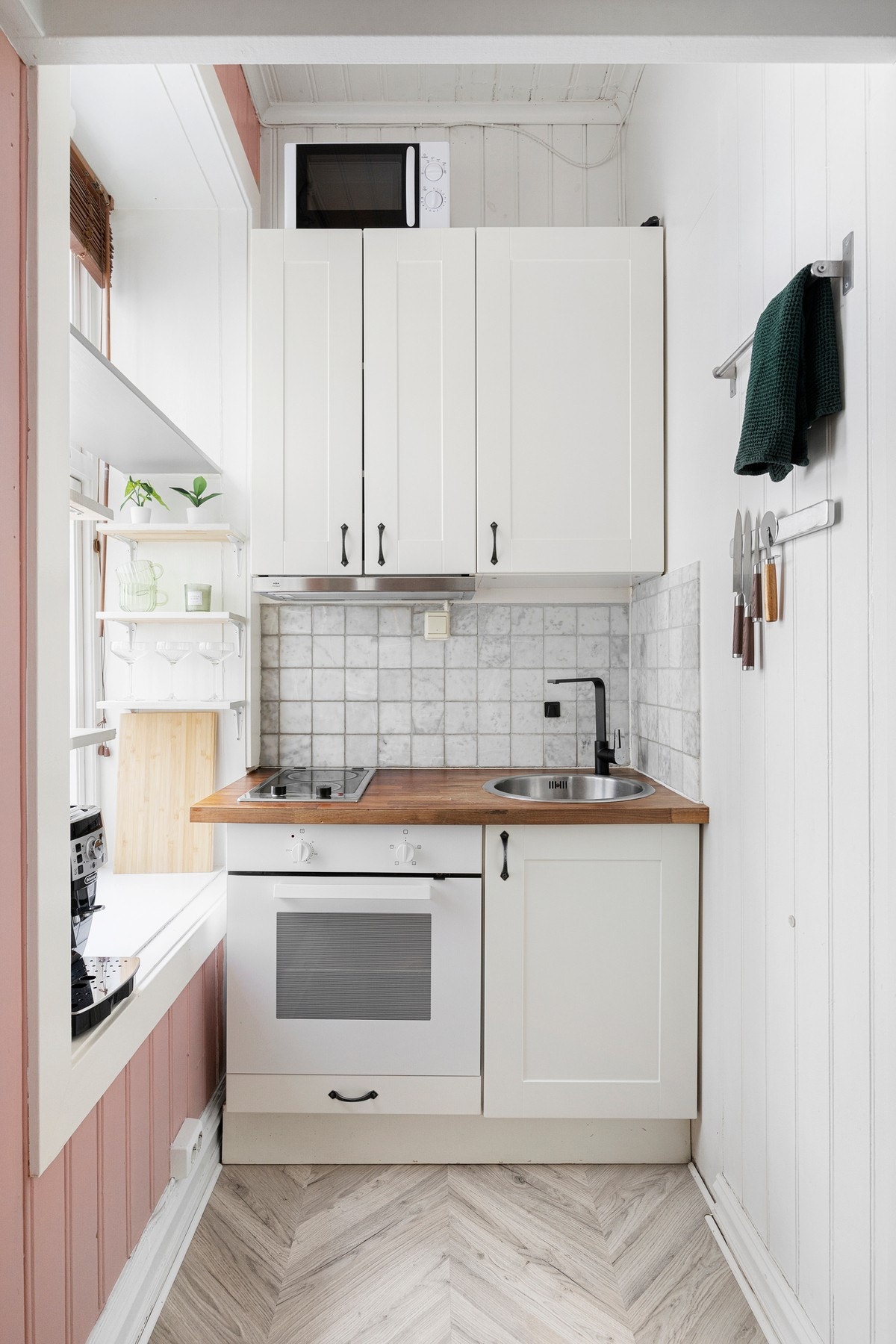 Kjøkkeninnredning med glatte fronter og fliser på vegg over benkeskap. Heltre benkeplate med nedfelt kum i rustfritt stål. Galleribilde